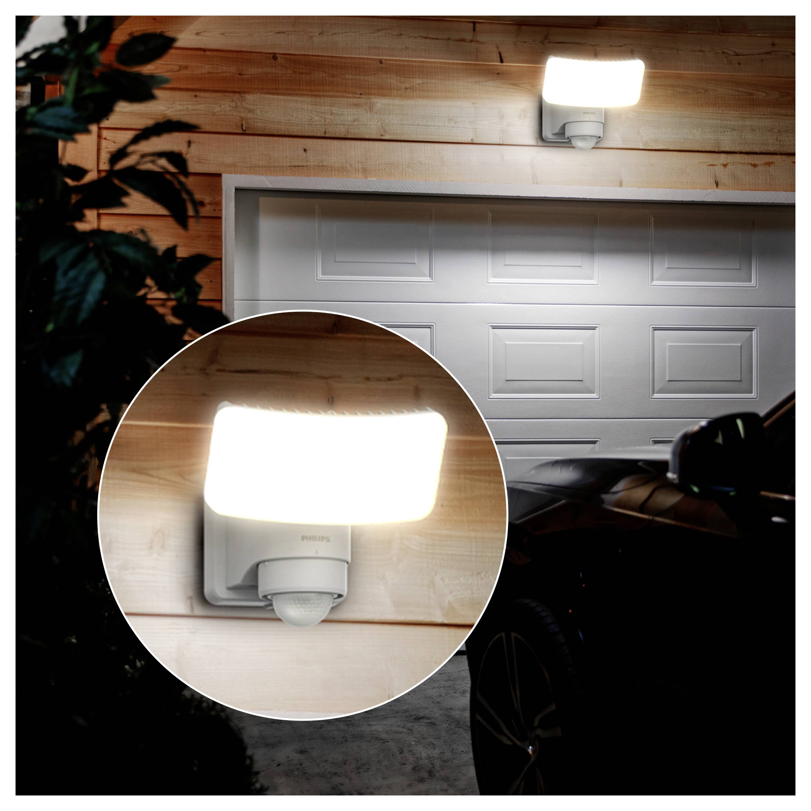 Helder bewegingsgeactiveerd buitenmuurlicht gemonteerd boven een garagedeur 's nachts, weergegeven met een ronde close-upinzet van de lamp.