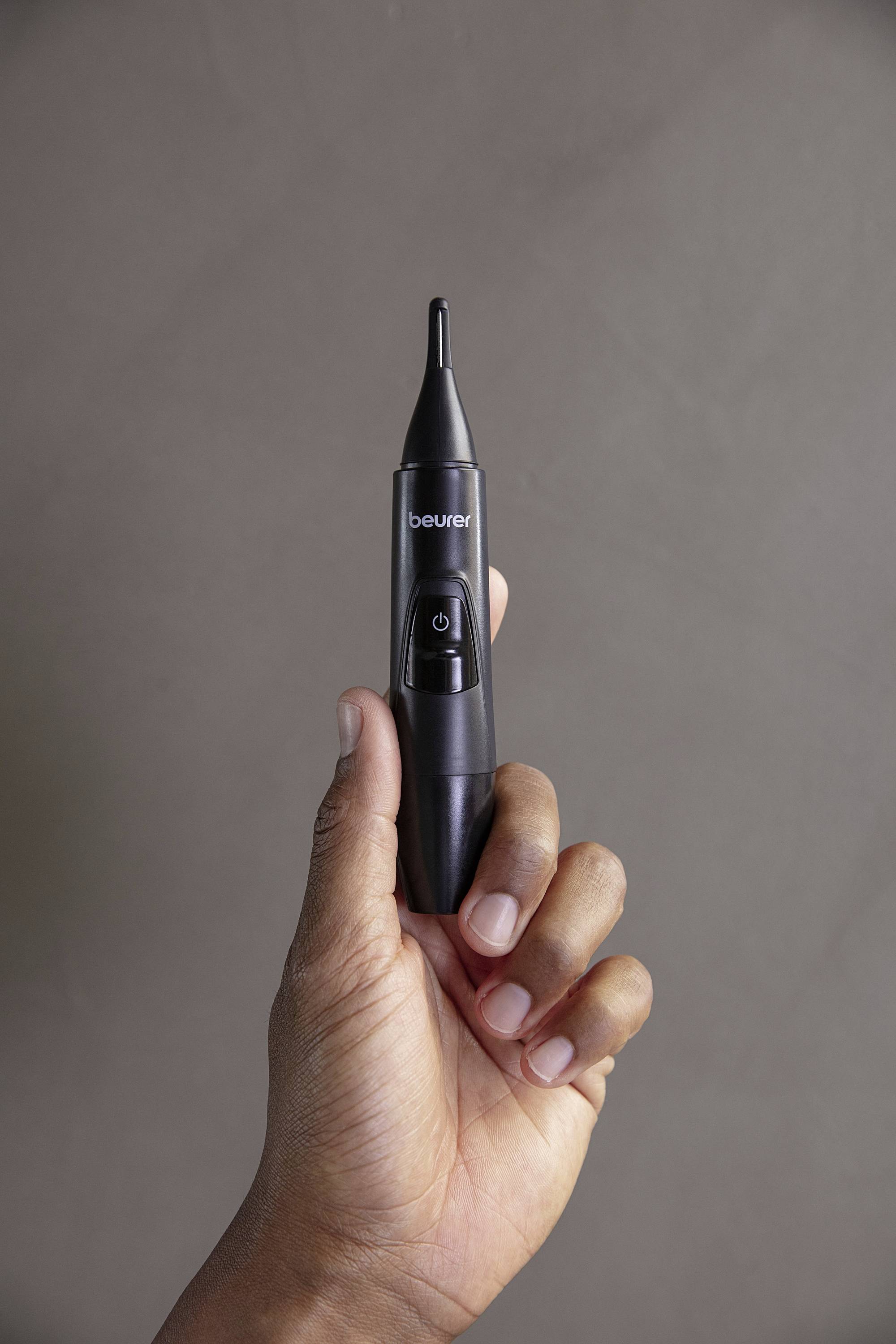 Een hand houdt een zwarte oorthermometer vast.