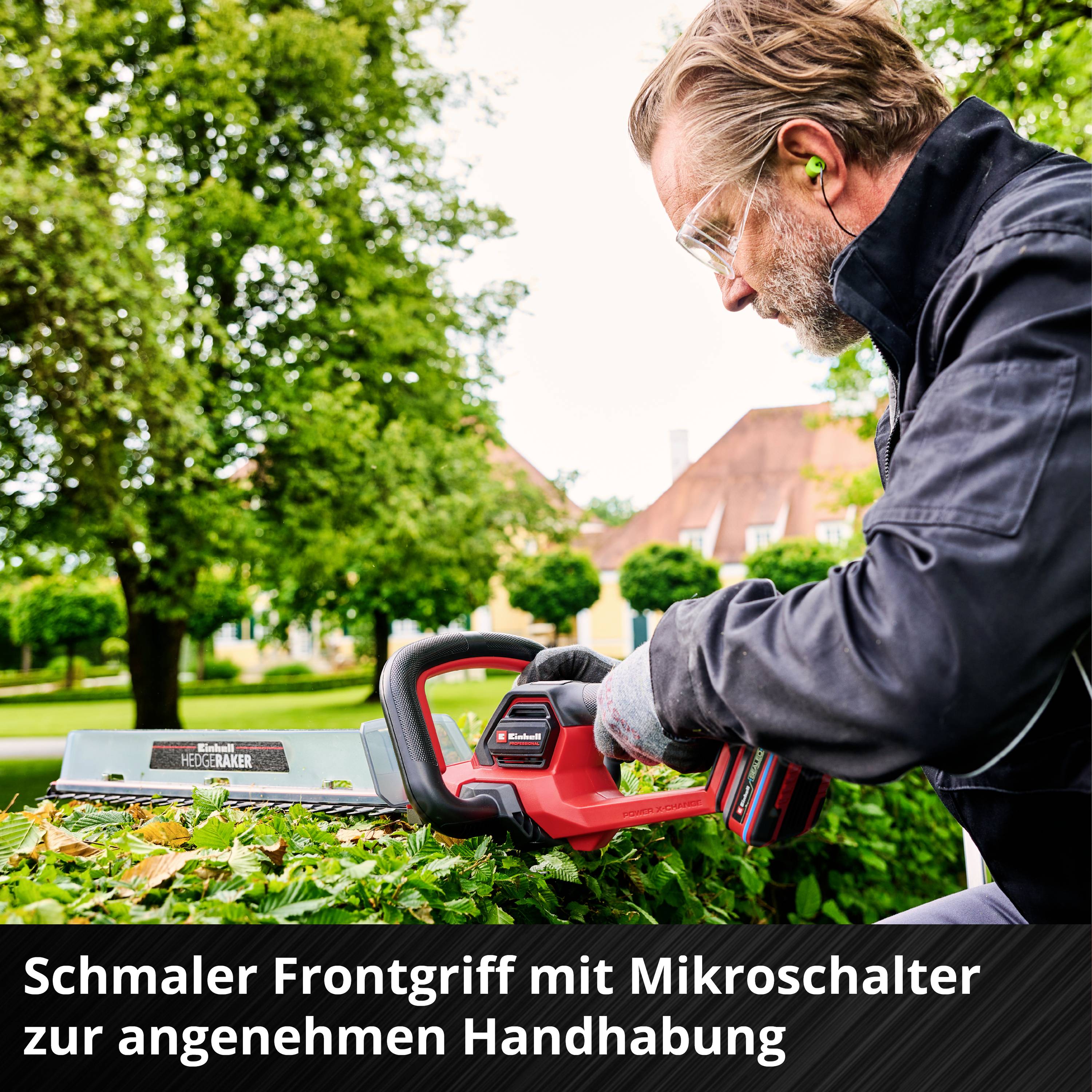 Man met veiligheidsbril knipt een haag met elektrische heggenschaar in de tuin. Tekst: 'Smalle frontgreep met microschakelaar voor comfortabele bediening'.