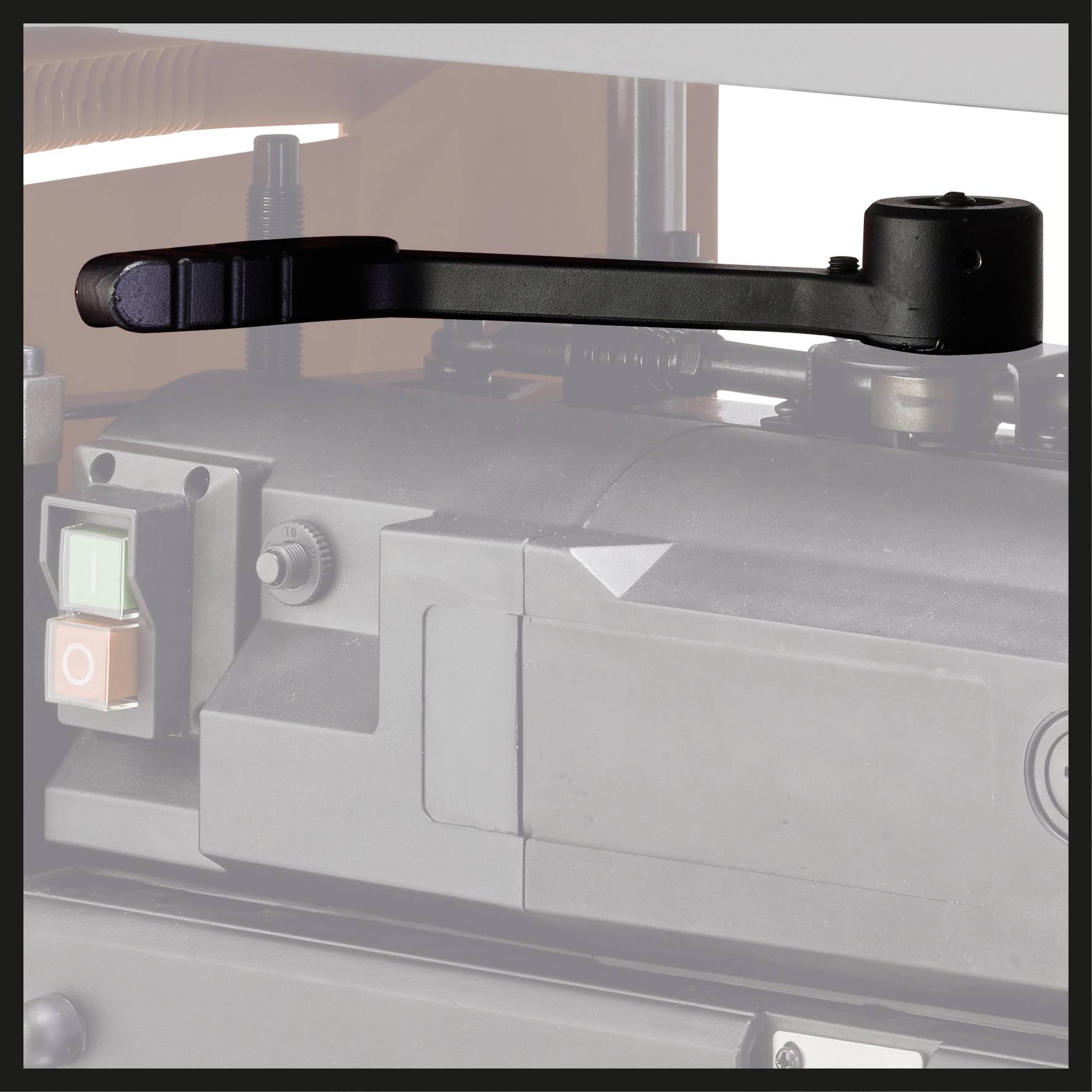 Zwarte machinehandgreep voor een grijze industriemachine met bedieningselementen.