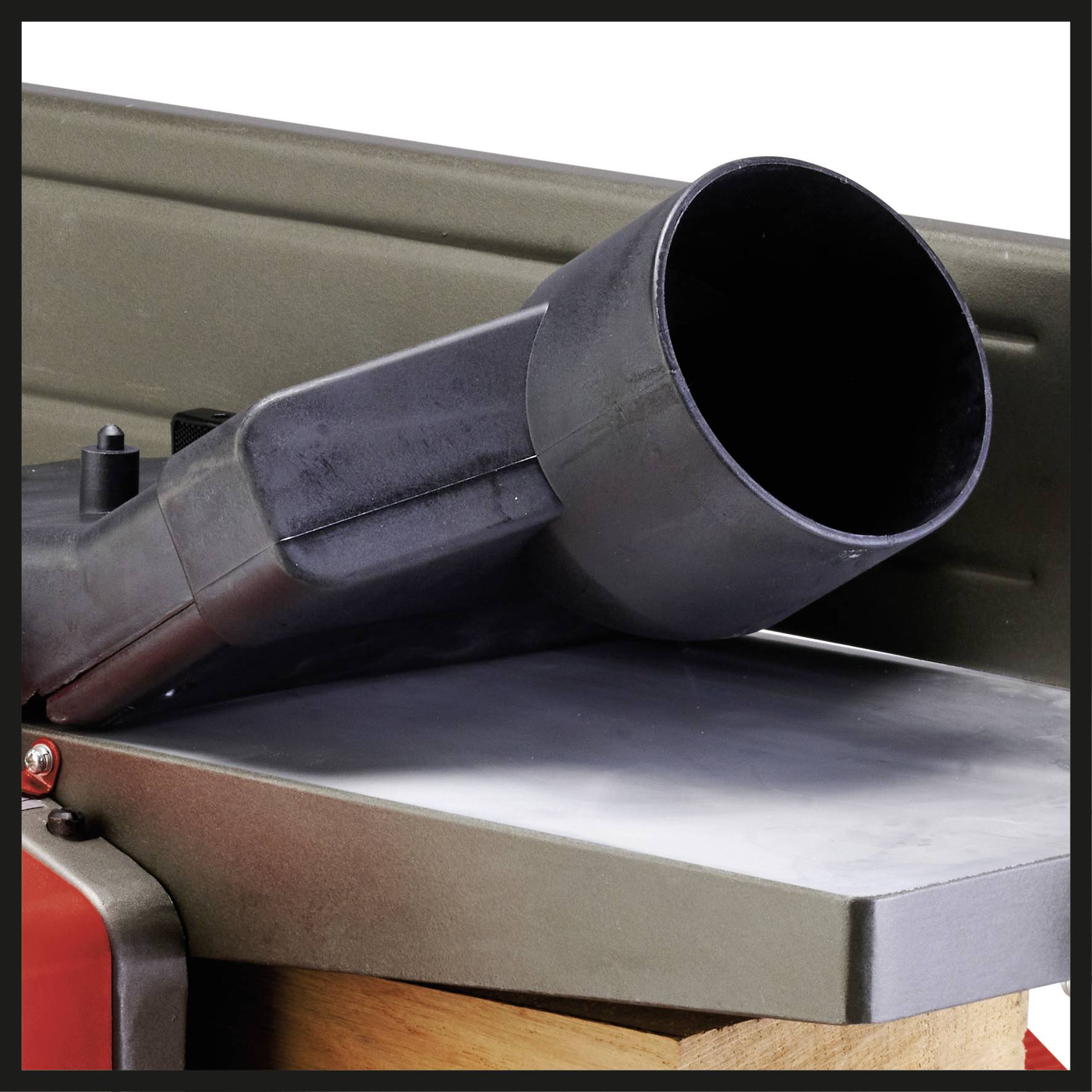 Een grote zwarte afzuigslang is gemonteerd op een metalen oppervlak. De context wijst op een werkplaats- of industriële omgeving.