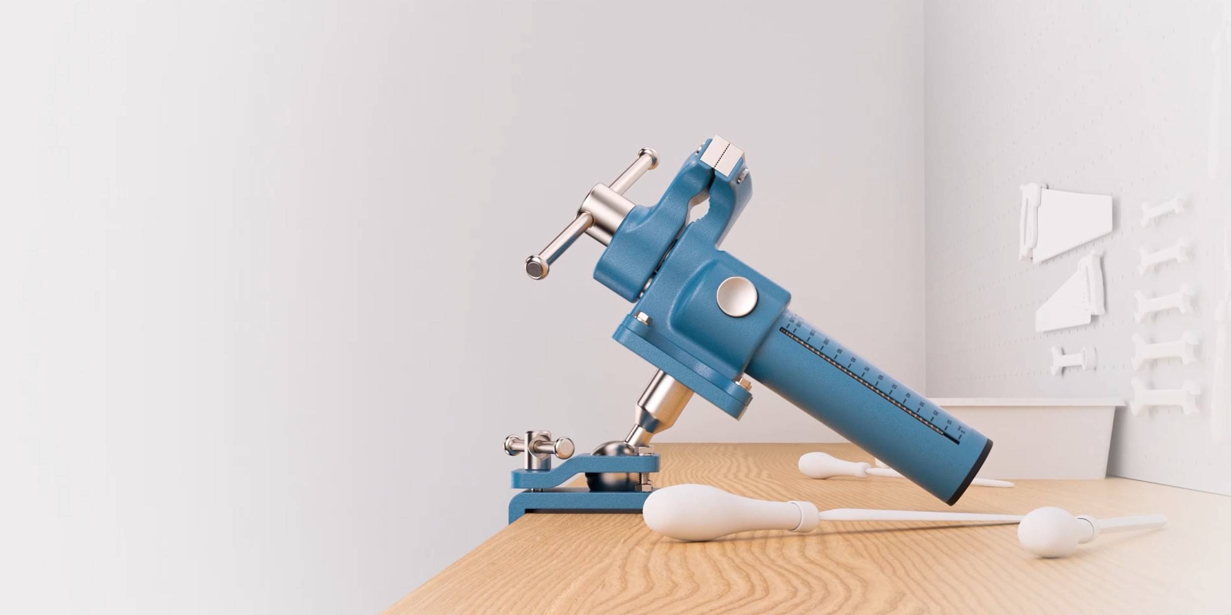 Op een tafel staat een blauw keukenhulpmiddel dat eruitziet als een handmatige vleesmolen, ernaast liggen witte keukengerei.