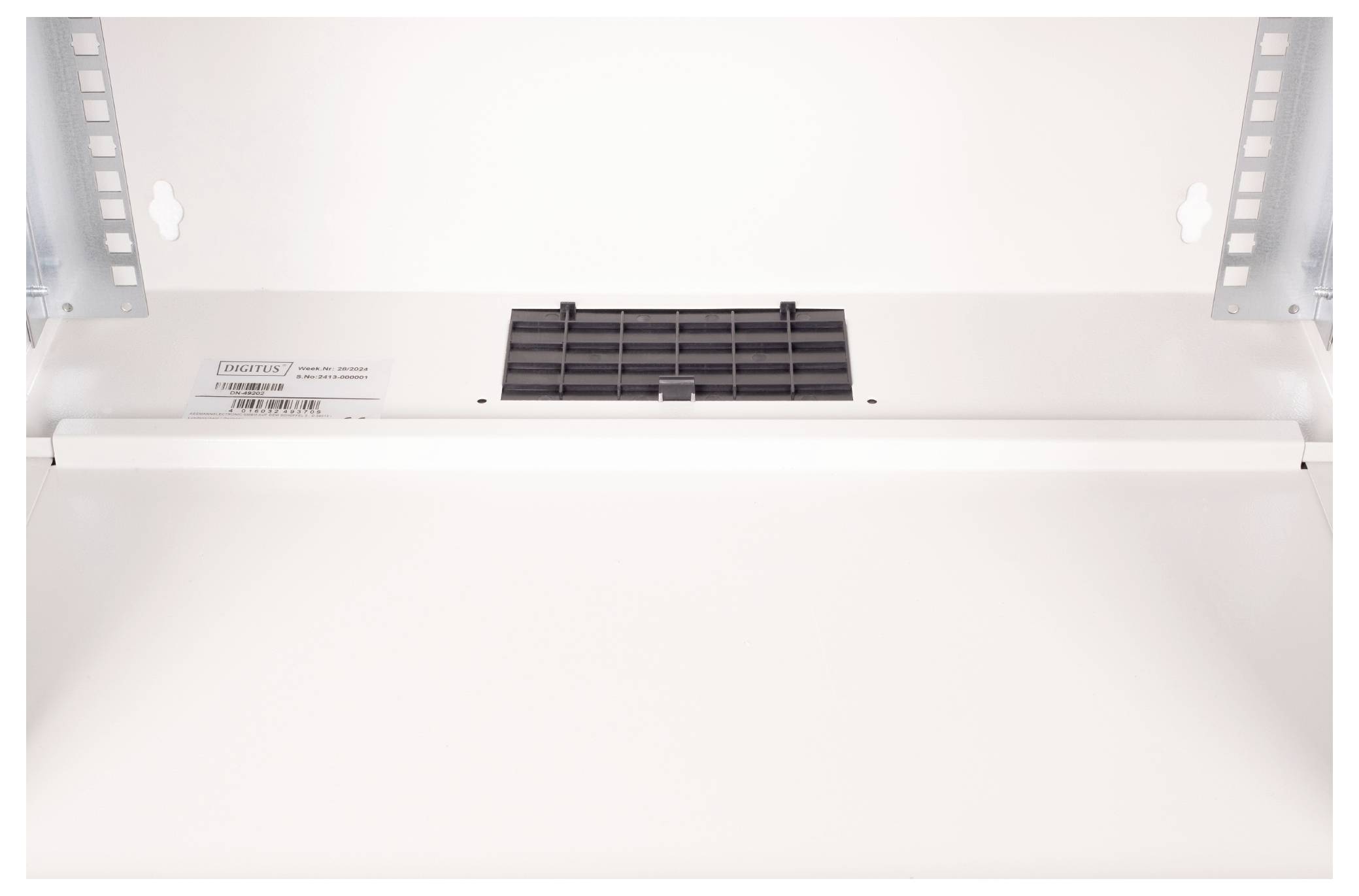 Een close-upfoto van het plafond van een Indesit-oven, waarbij een ventilatierooster en lichtarmatuur zichtbaar zijn, die zorgen voor ventilatie en verlichting.