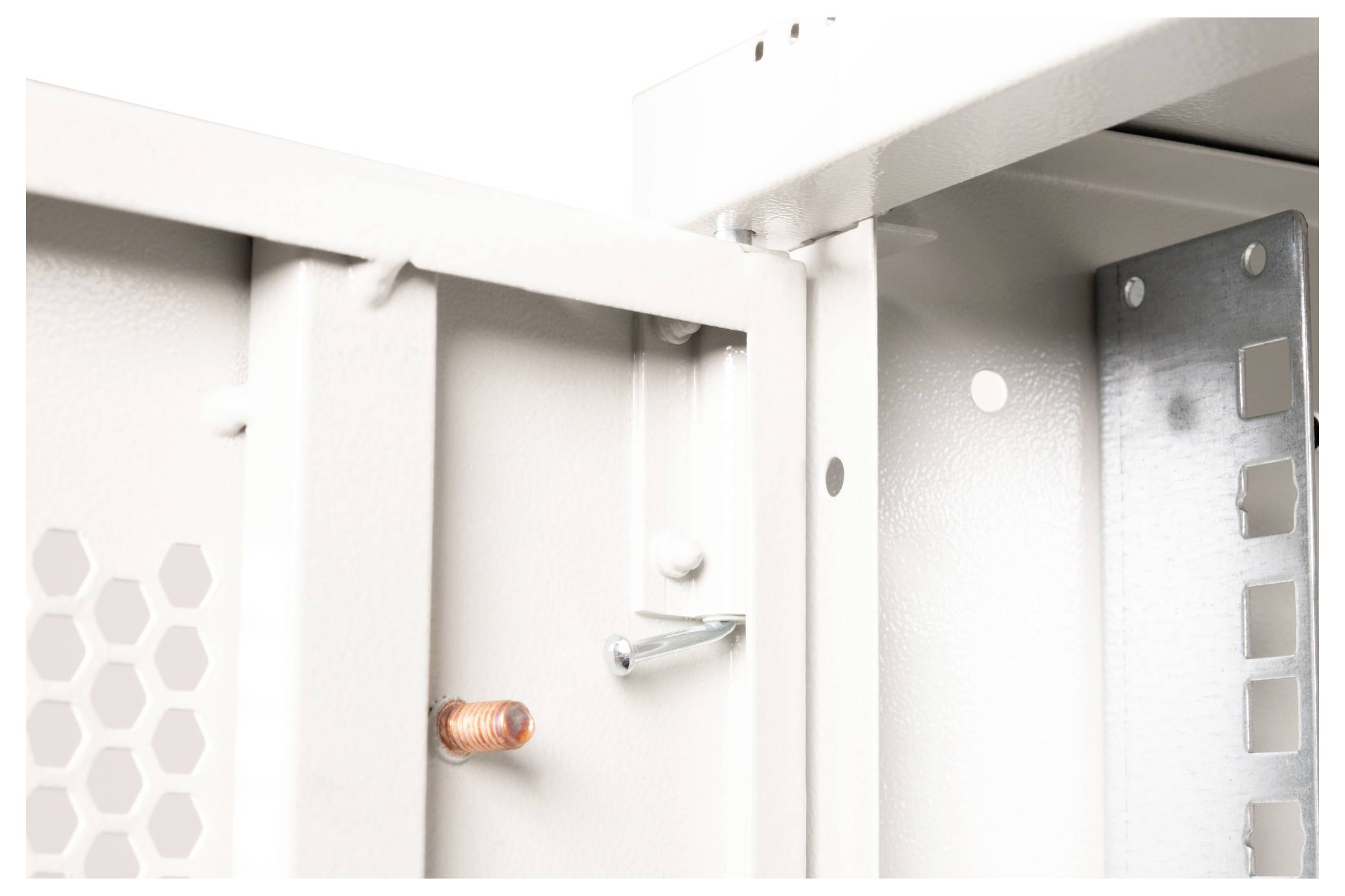 Close-up van een binnenkant van een lichtgekleurd metalen behuizing, waarop structurele verbindingen en componenten zichtbaar zijn. Een koperen bout en andere interne details zijn te zien.