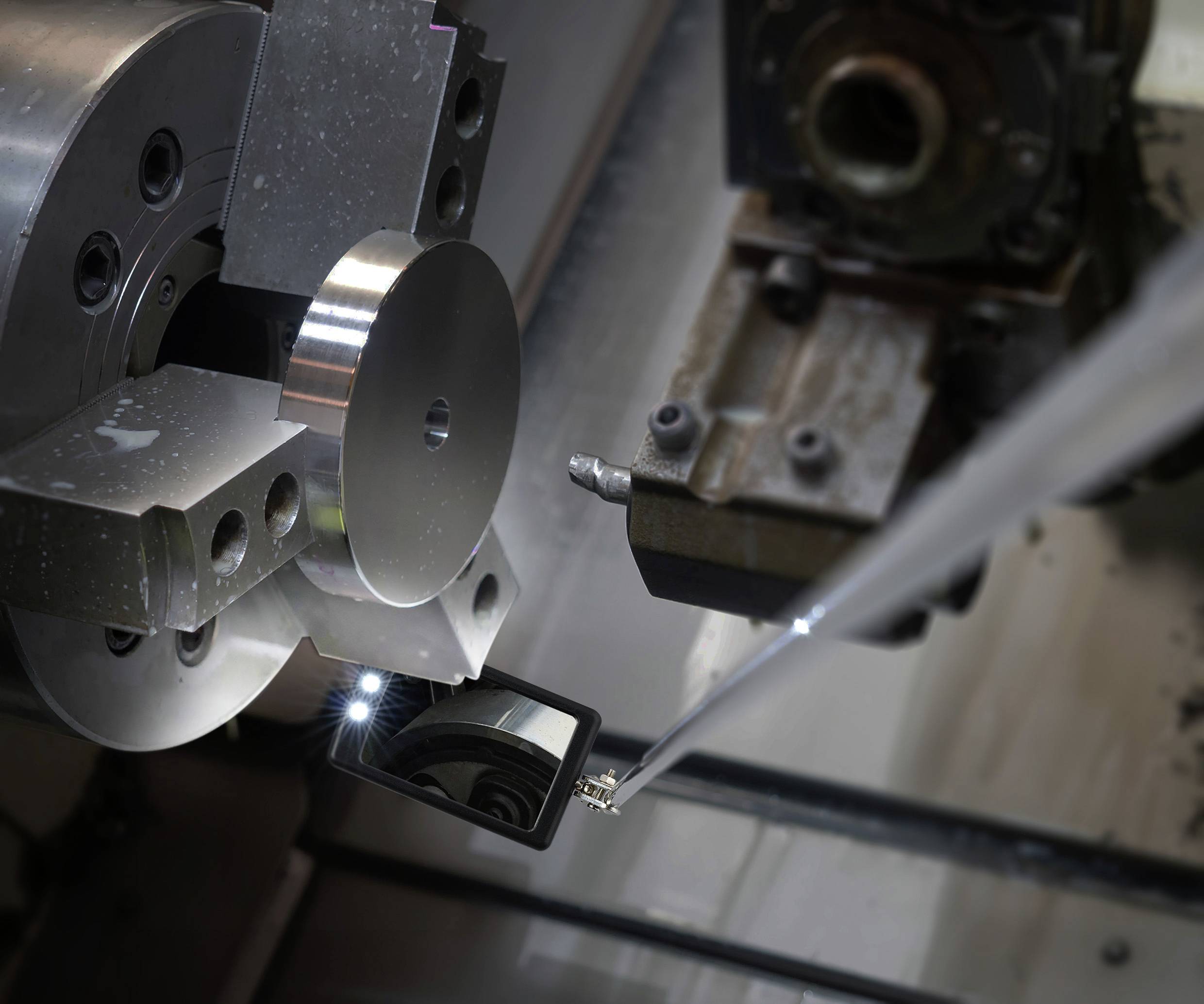 Een draaibank bewerkt een metalen onderdeel. De focus ligt op het roterende werkstuk en de precisiebewerking.