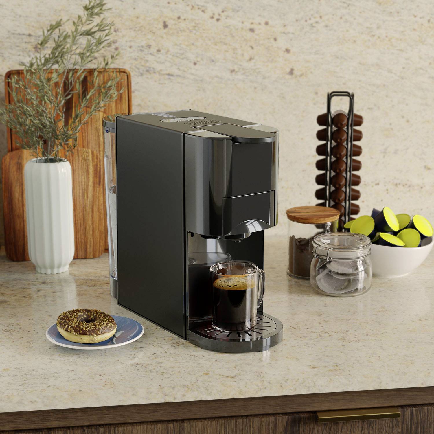 Een zwarte koffiemachine staat op een aanrecht. Ernaast staan glazen containers met koffiecapsules. Er wordt momenteel een espresso gezet.