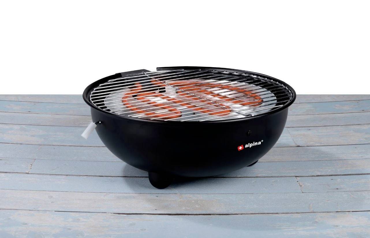 Een ronde elektrische grill met een metalen rooster op een blauwe houten ondergrond. De verwarmingsstang is rood verlicht.