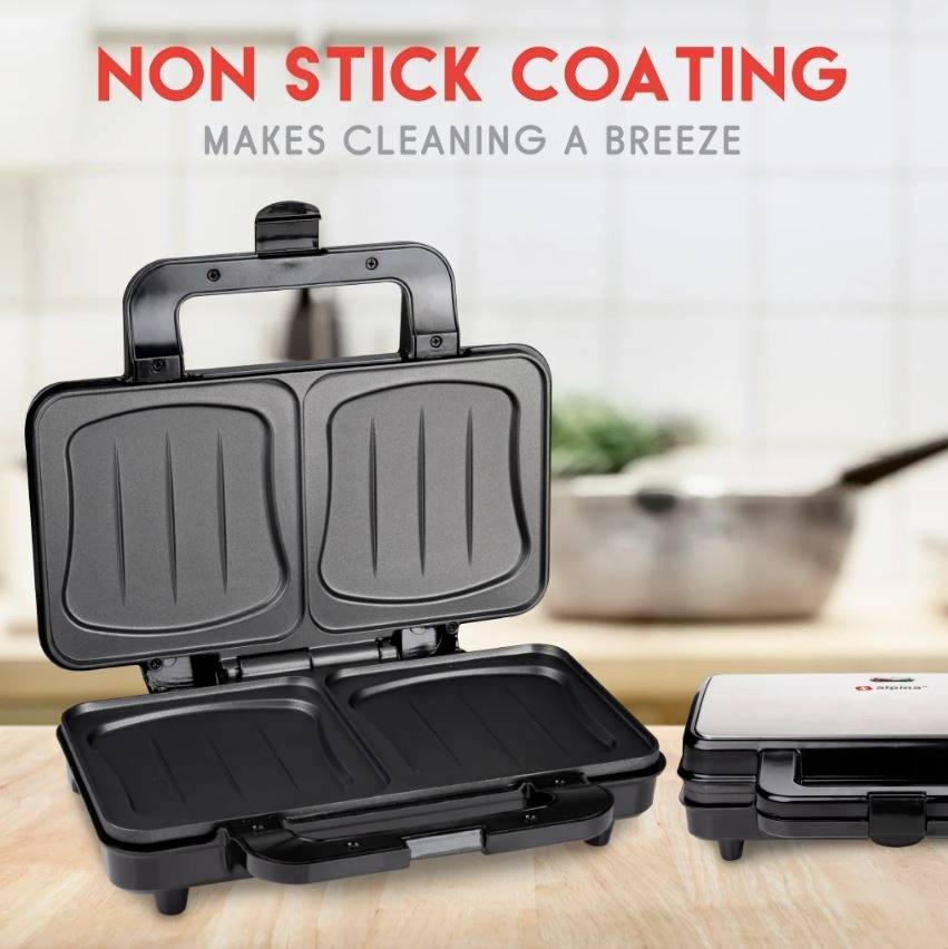 Een dubbele tosti-ijzer met anti-aanbaklaag op een aanrecht. Achtergrond toont een wazig keukentafereel.