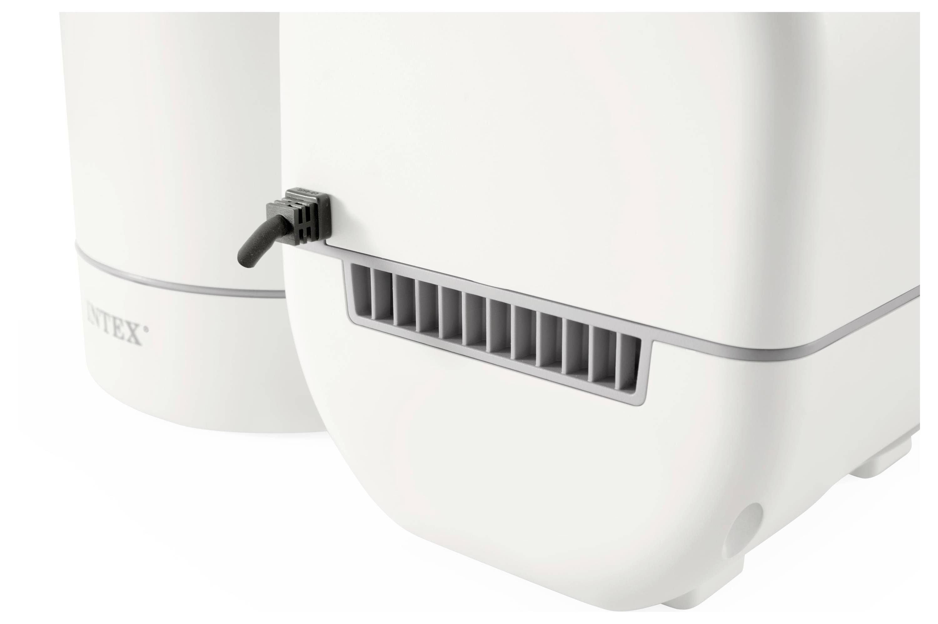 Wit apparaat met ventilatiesleuven en kabelaansluiting; onderdeel van een groter technisch systeem.