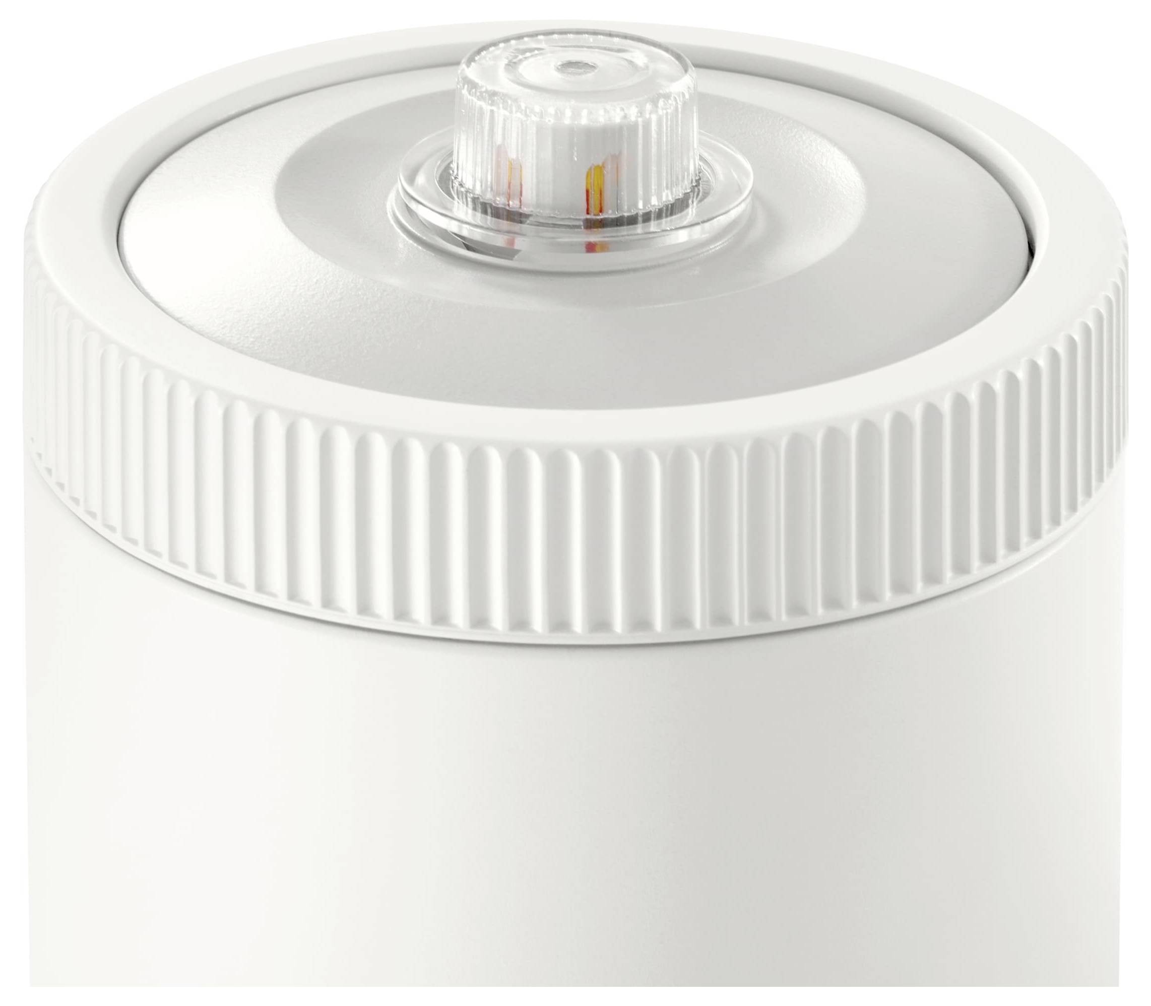 Een witte draaidop van een fles met een kleine, transparante, gegroefde dop waarop een maatvenster zichtbaar is.