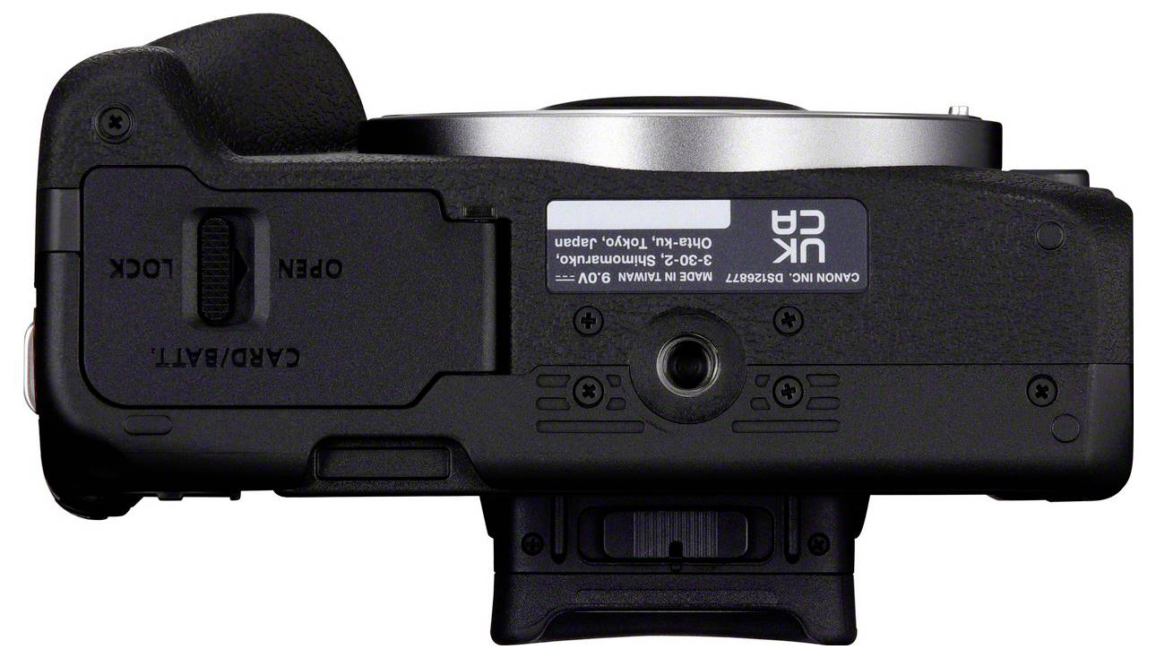 Onderkant van een camera met batterijvak en vergrendelingsmechanisme. Tekstindicaties van oorsprong en modelnummer zichtbaar.