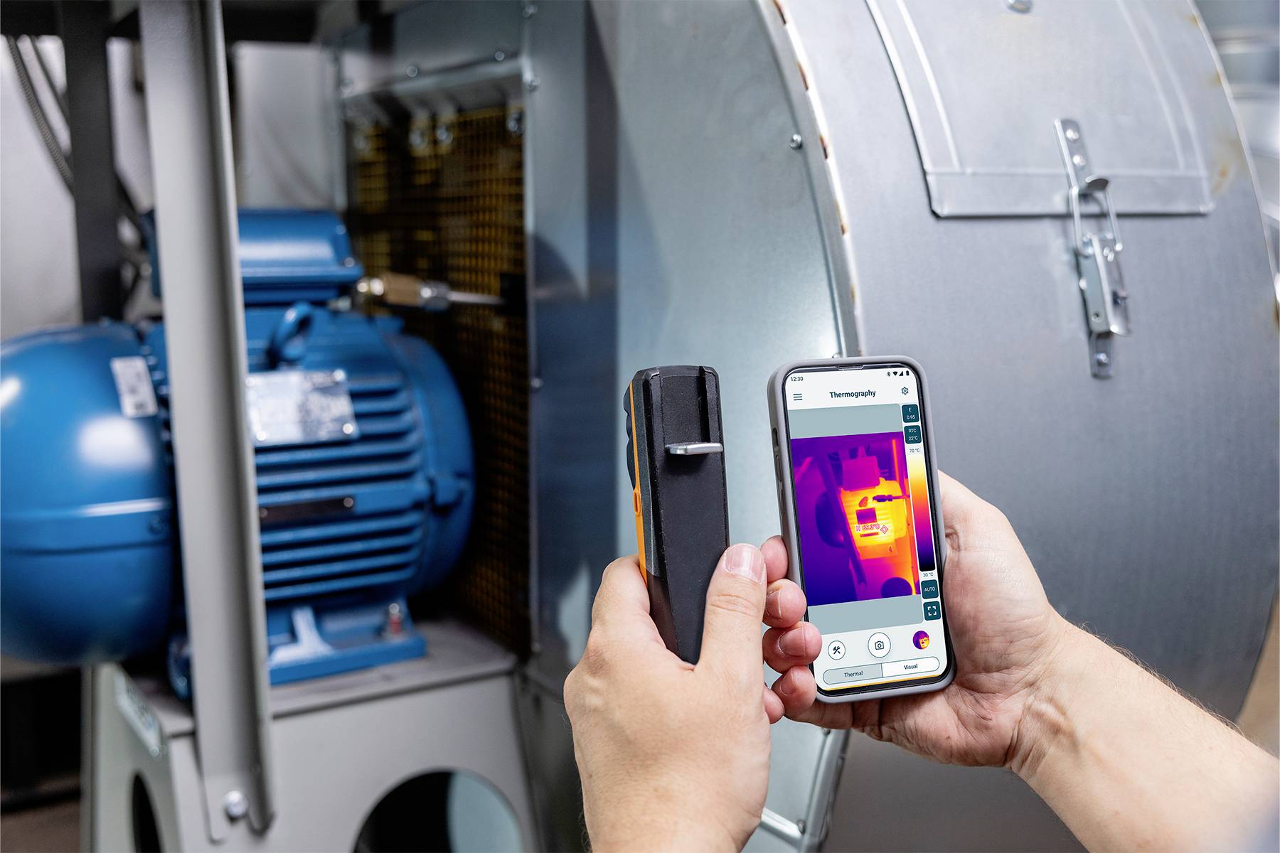 Een persoon gebruikt een infrarood-thermometer en toont het resultaat op een smartphone. De temperatuur van een grote motor wordt gemeten.