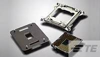Drie metalen componenten op een grijze achtergrond, mogelijk onderdelen van een computerprocessor of koeler, liggen naast elkaar.
