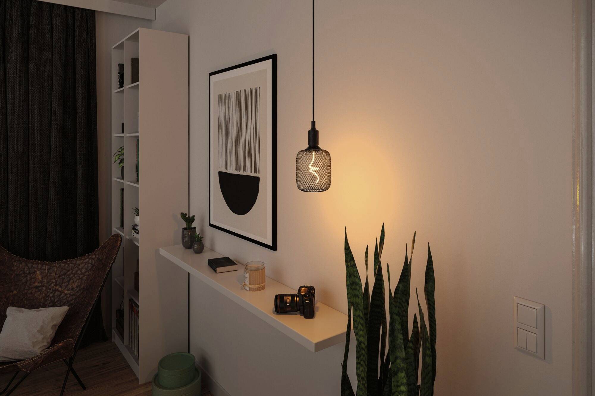 Een minimalistische hoek van een woonkamer. Aan de muur hangen een zwart-wit kunstwerk en een verlichtingsarmatuur. Op de plank staat een camera.