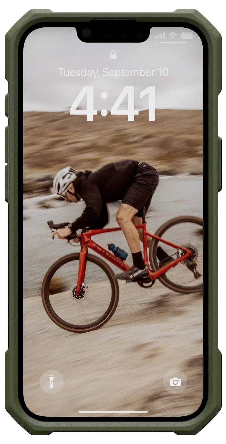 Een wielrenner in sportieve kleding rijdt snel op een rood fiets over een wazig, rotsachtig landschap.