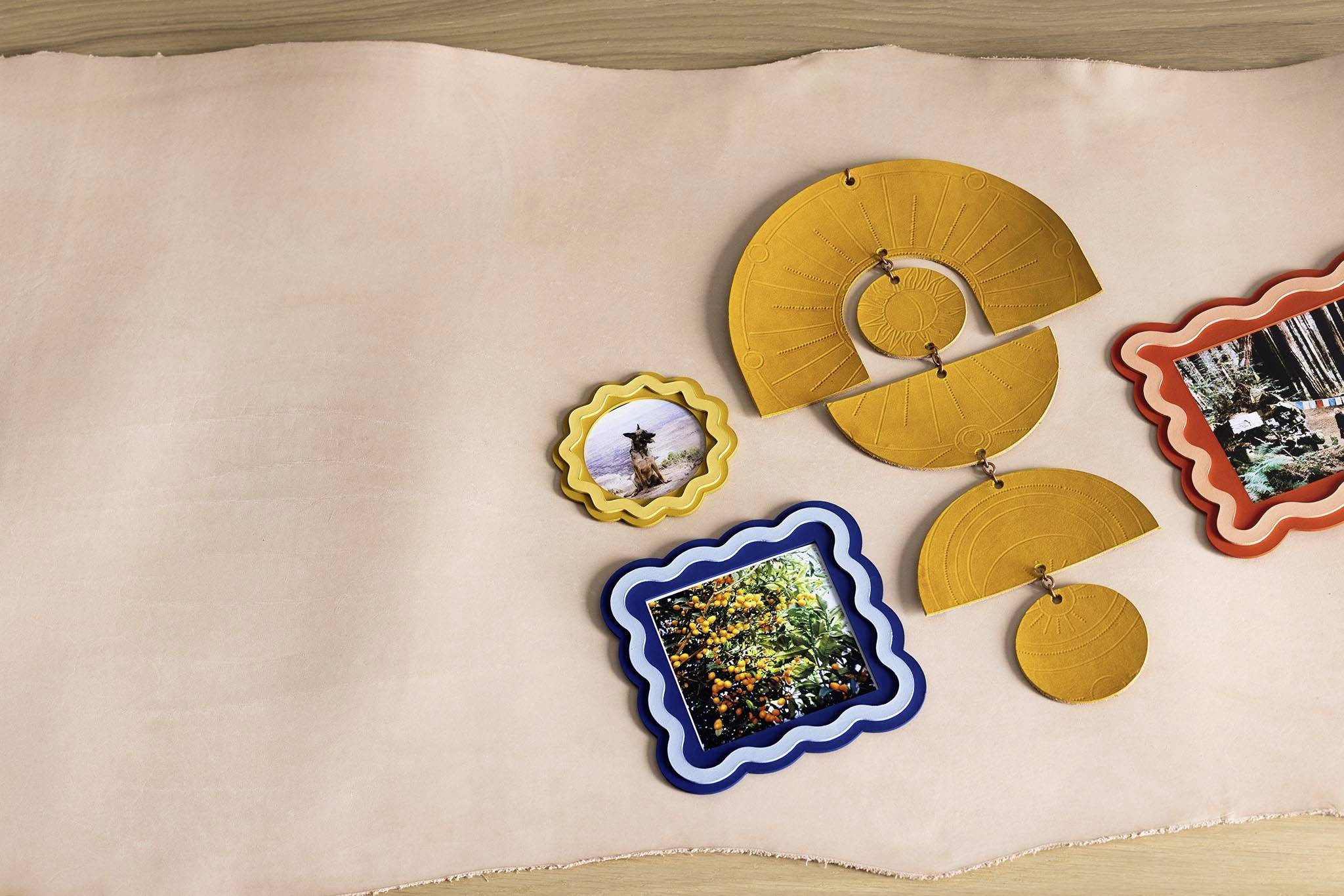 Verschillende gekleurde lijsten met natuurfoto's, gerangschikt op een beige doek. De nadruk ligt op de foto's en de creatieve opstelling.