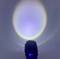 Zaklamp schijnt tegen een muur en creëert een helder lichtcirkel met een blauwe en gele rand.