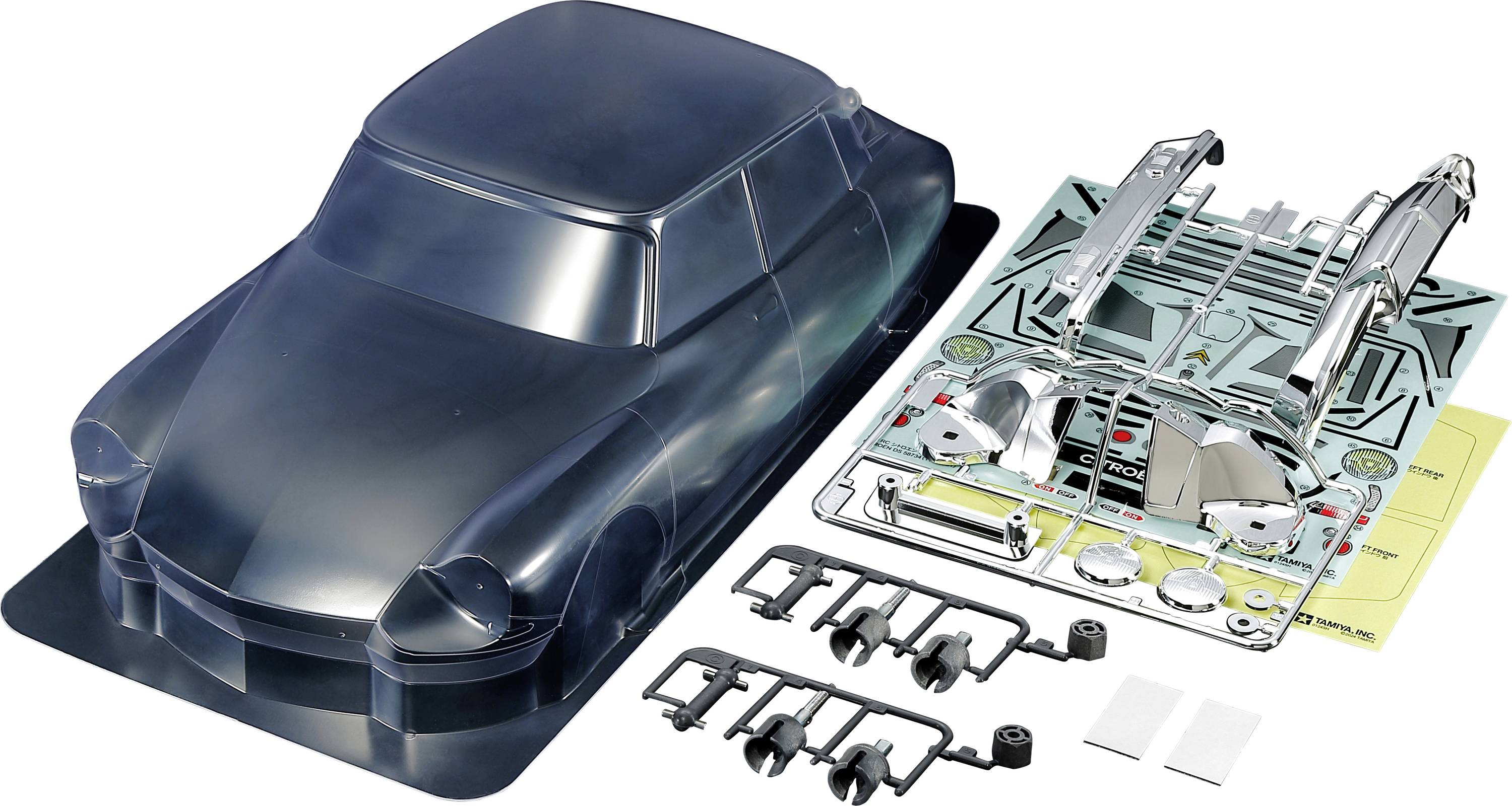 Bouwpakket van een modelauto met een transparante carrosserie en losse onderdelen op een tafel, klaar om in elkaar gezet te worden.