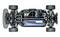 RC-autochassis van bovenaf met zichtbare componenten: motor, bedrading, batterijen en ophanging. Vier banden links en rechts.