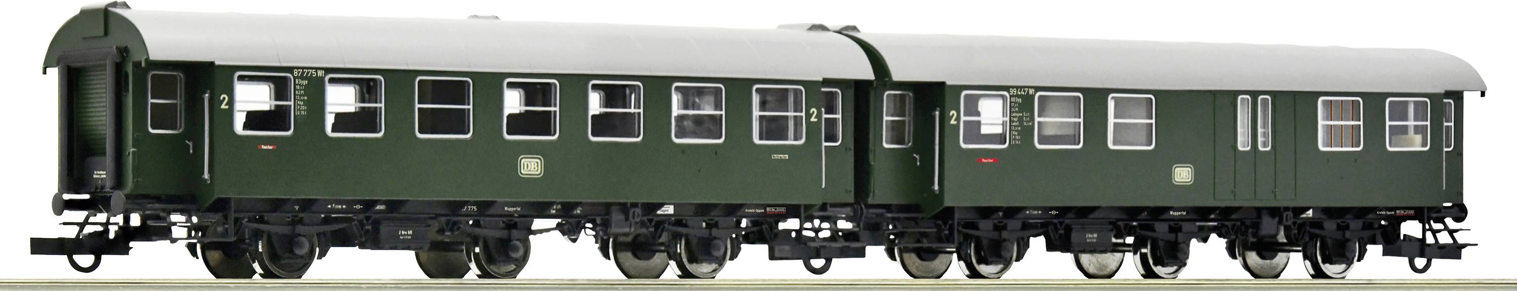 Twee groene, historische spoorwegwagons met zwarte wielen staan naast elkaar. Ze hebben meerdere ramen en metalen verstevigingen.