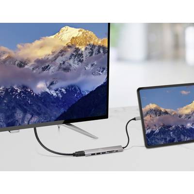 'Een laptop verbonden met een monitor toont dezelfde bergscène met een zonsondergang, wat apparaatconnectiviteit en schermspiegeling demonstreert.'