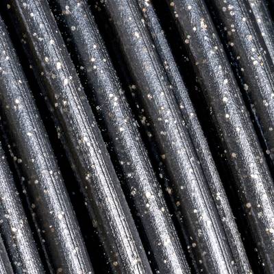 Close-up van glanzende, zwarte metalen staven met zilveren punten. Ze zijn parallel uitgelijnd en reflecteren licht.