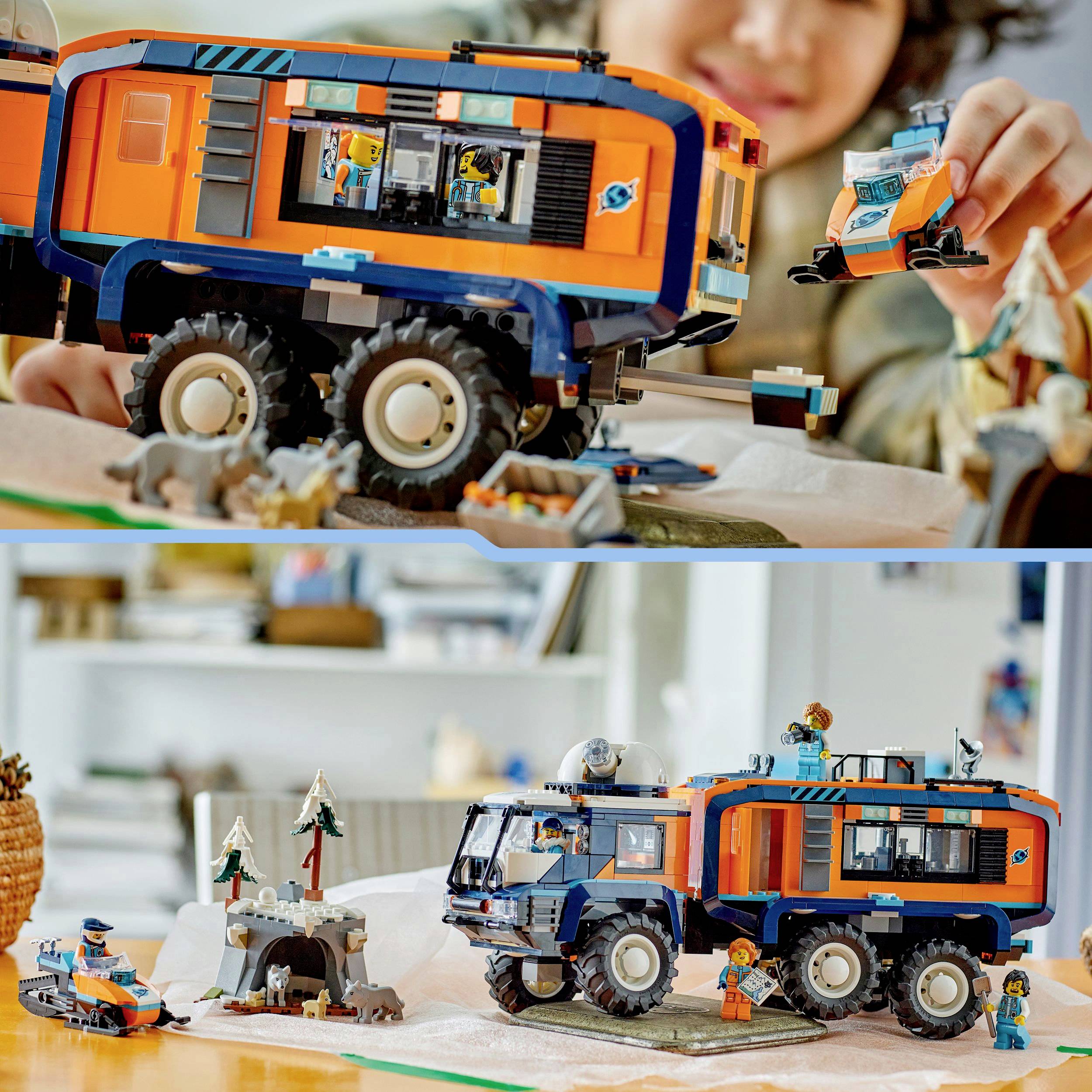 Een kind speelt met een grote, oranje-blauwe speelgoed-truck en zet er een kleine oranje-blauwe figuur op. Op de achtergrond zijn meer figuren en diorama-elementen te zien.