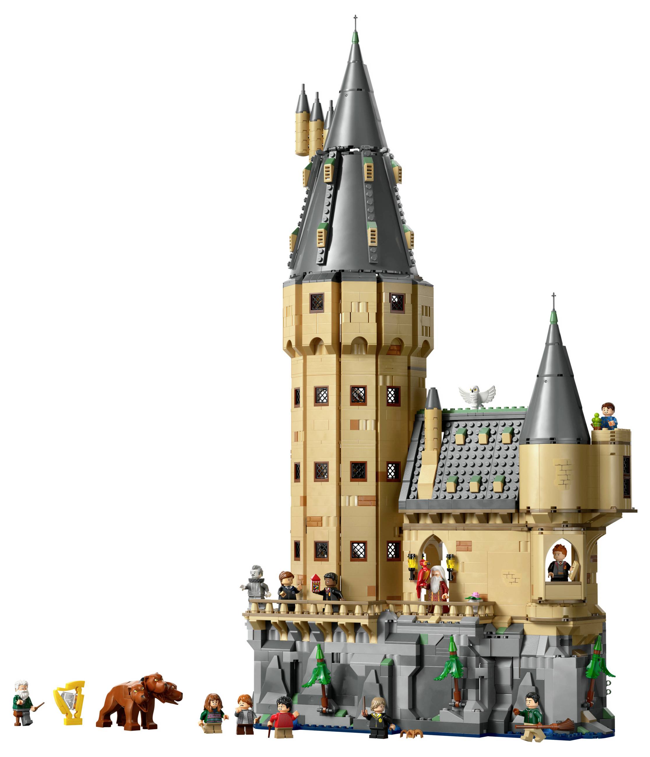 Een gedetailleerde Lego-set toont een groot kasteel met meerdere figuren. Enkele figuren staan voor het kasteel, een standbeeld staat op de toren.
