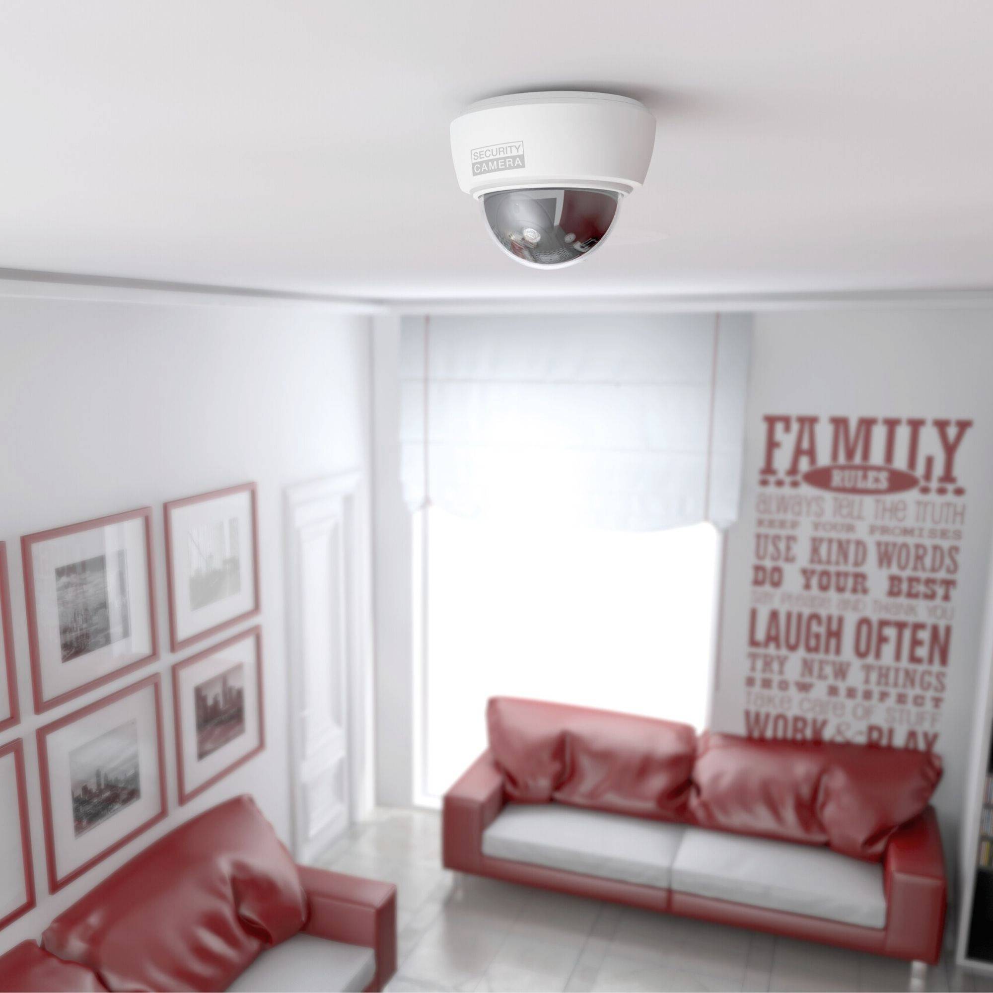 Een bewakingscamera is aan het plafond van een woonkamer bevestigd, ingericht met een bank en ingelijste foto's.