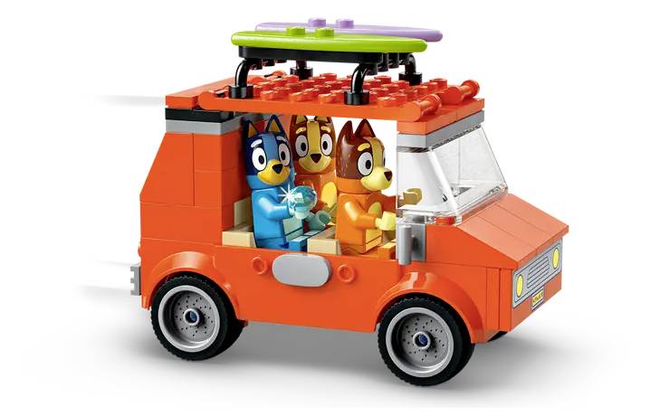 Een speelgoedbestelwagen gemaakt van kleurrijke bouwblokken met drie cartooneske hondenfiguren binnenin, die een speelse scène verbeelden.