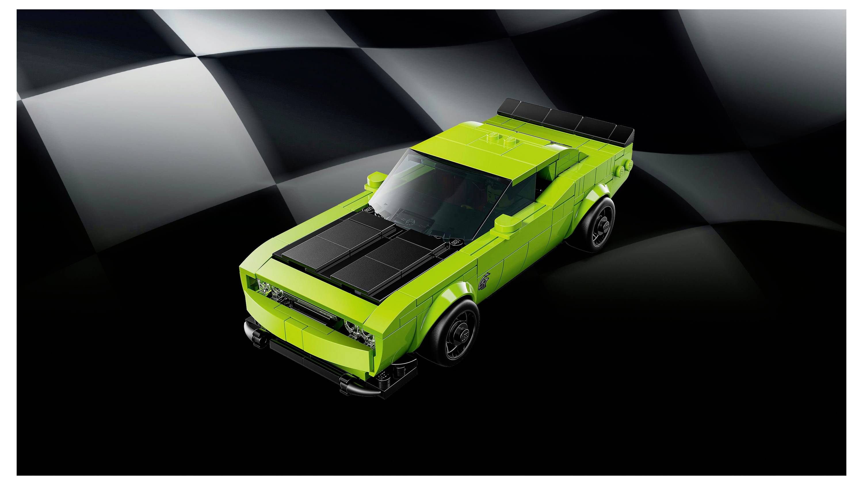 Een felgroene speelgoedauto met zwarte details, tentoongesteld tegen een donkere, geruit achtergrond die doet denken aan de finishlijn van een racecircuit.