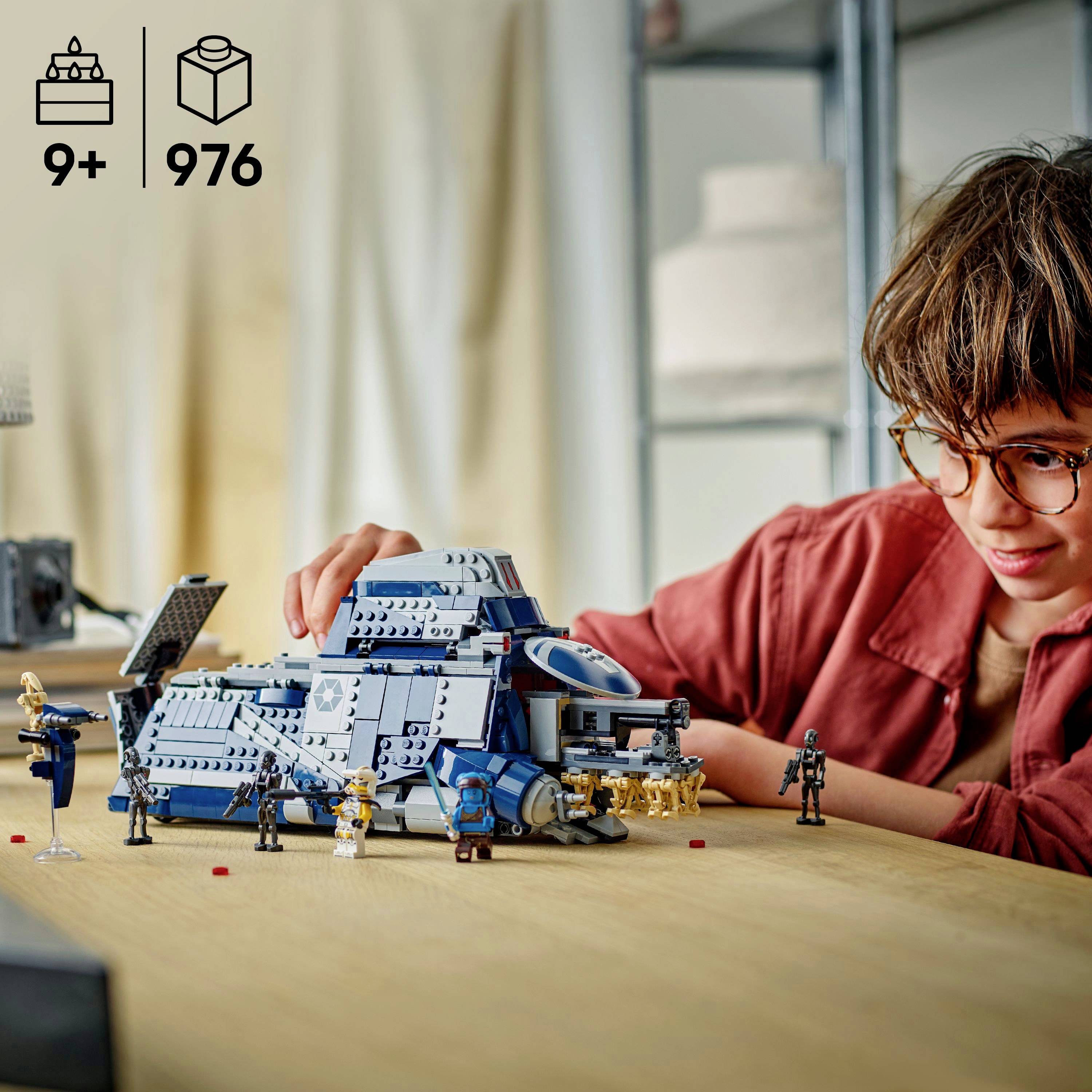 Een persoon is een gedetailleerd ruimteschipmodel aan het assembleren met figurines aan een houten tafel. De afbeelding geeft aan dat het 976 onderdelen bevat voor leeftijden 9 jaar en ouder.
