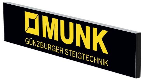 Bord met geel logo en tekst: 'MUNK - Günzburger Steigtechniek' op zwarte achtergrond. Bedrijfsteken links naast de tekst.