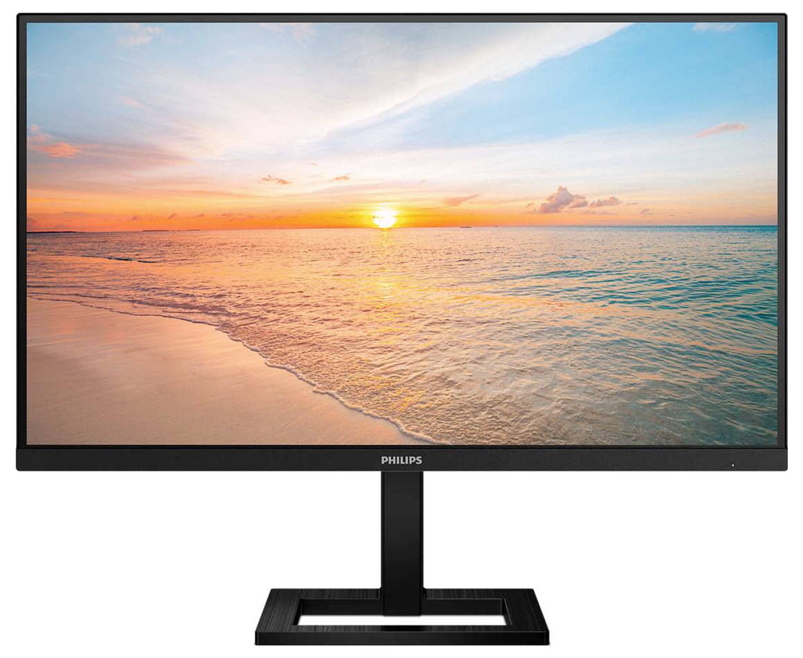 Een monitor toont een zonsondergang aan het strand, waarbij de hemel kleurrijk is en weerspiegeld wordt in het kalmte water.