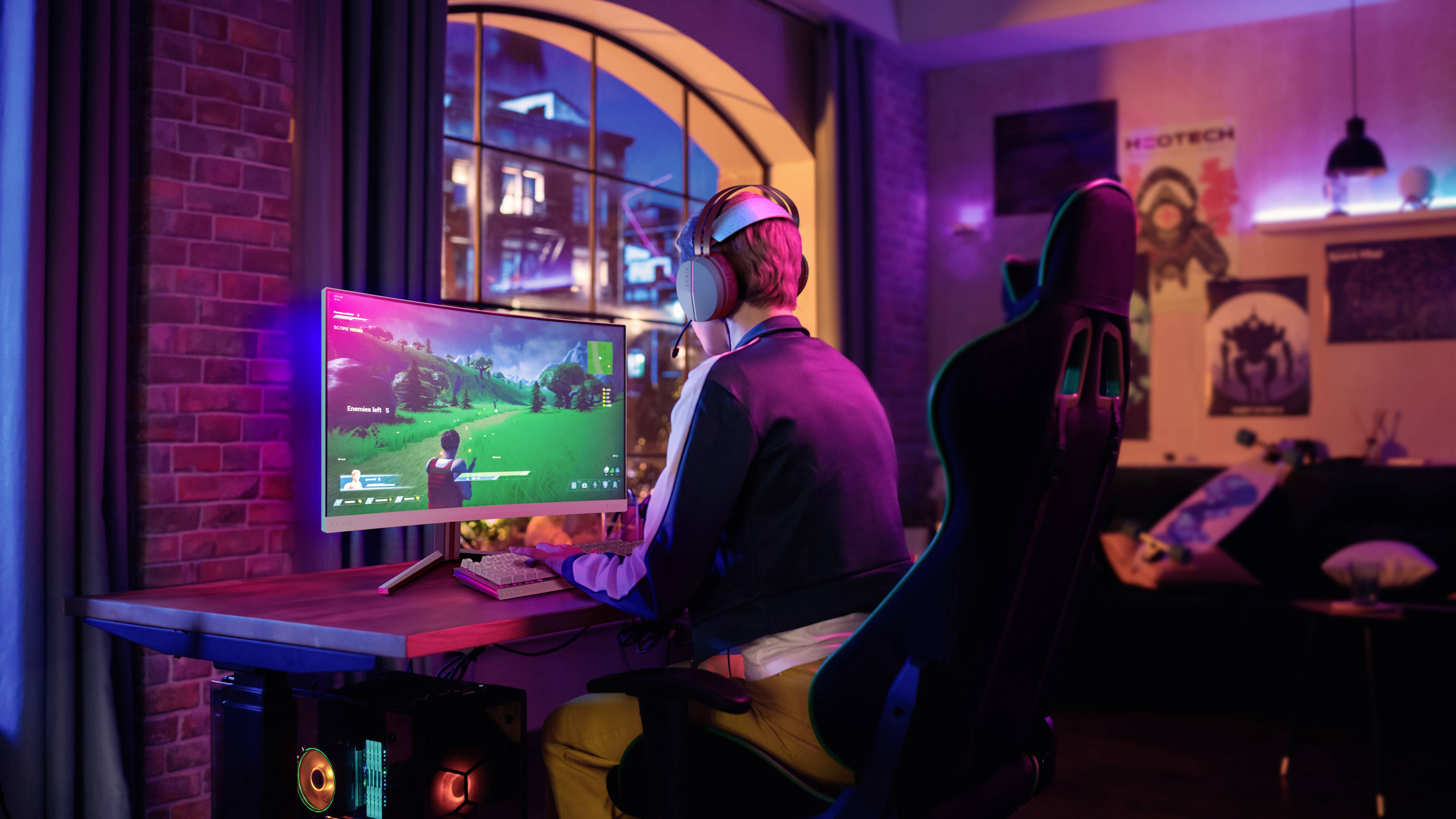 Een persoon speelt een videospel op de computer in een verduisterde ruimte. De scène oogt ontspannend en geconcentreerd.