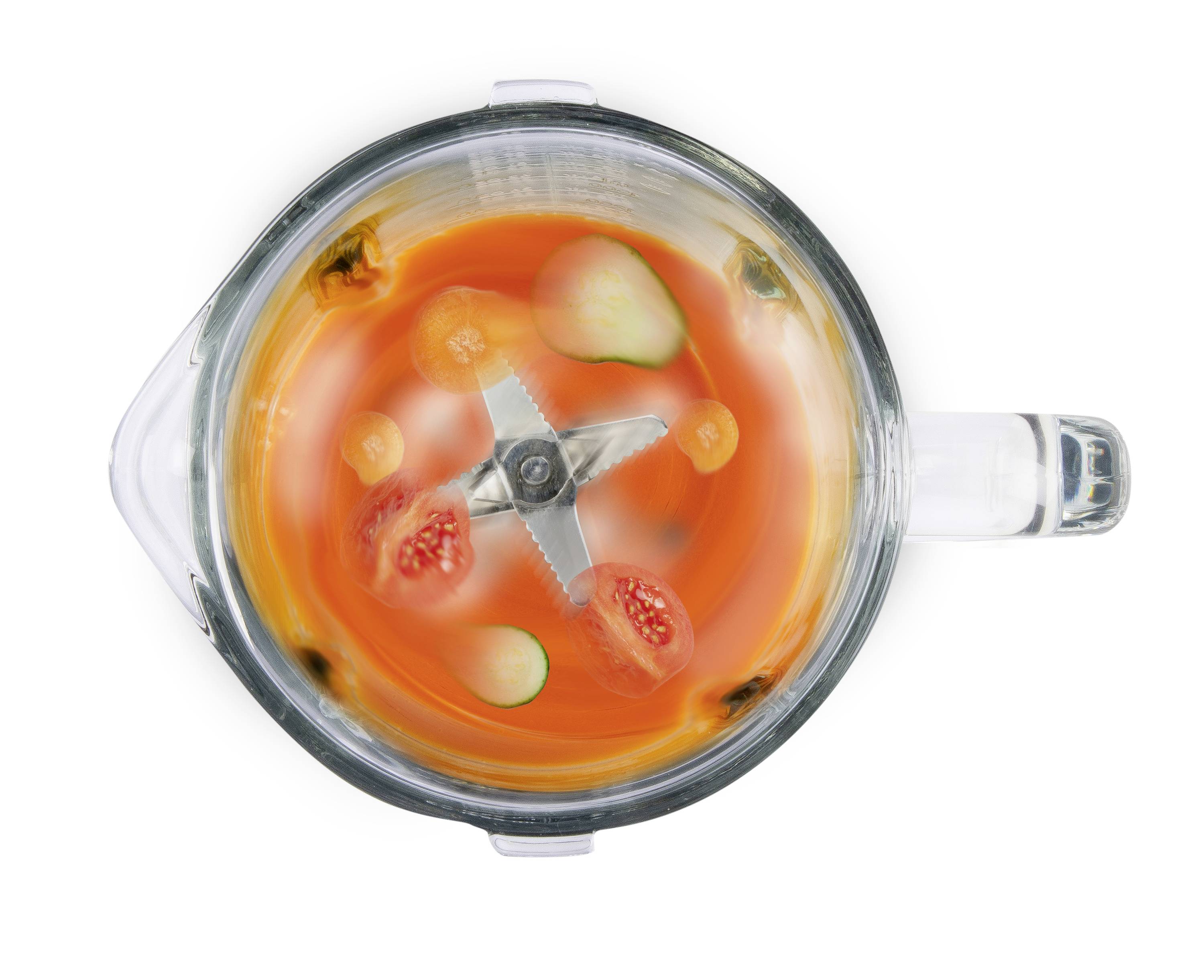 Mixer van bovenaf gezien, met grofgesneden tomaten, komkommerschijven en wortelstukjes in een oranje vloeistof.