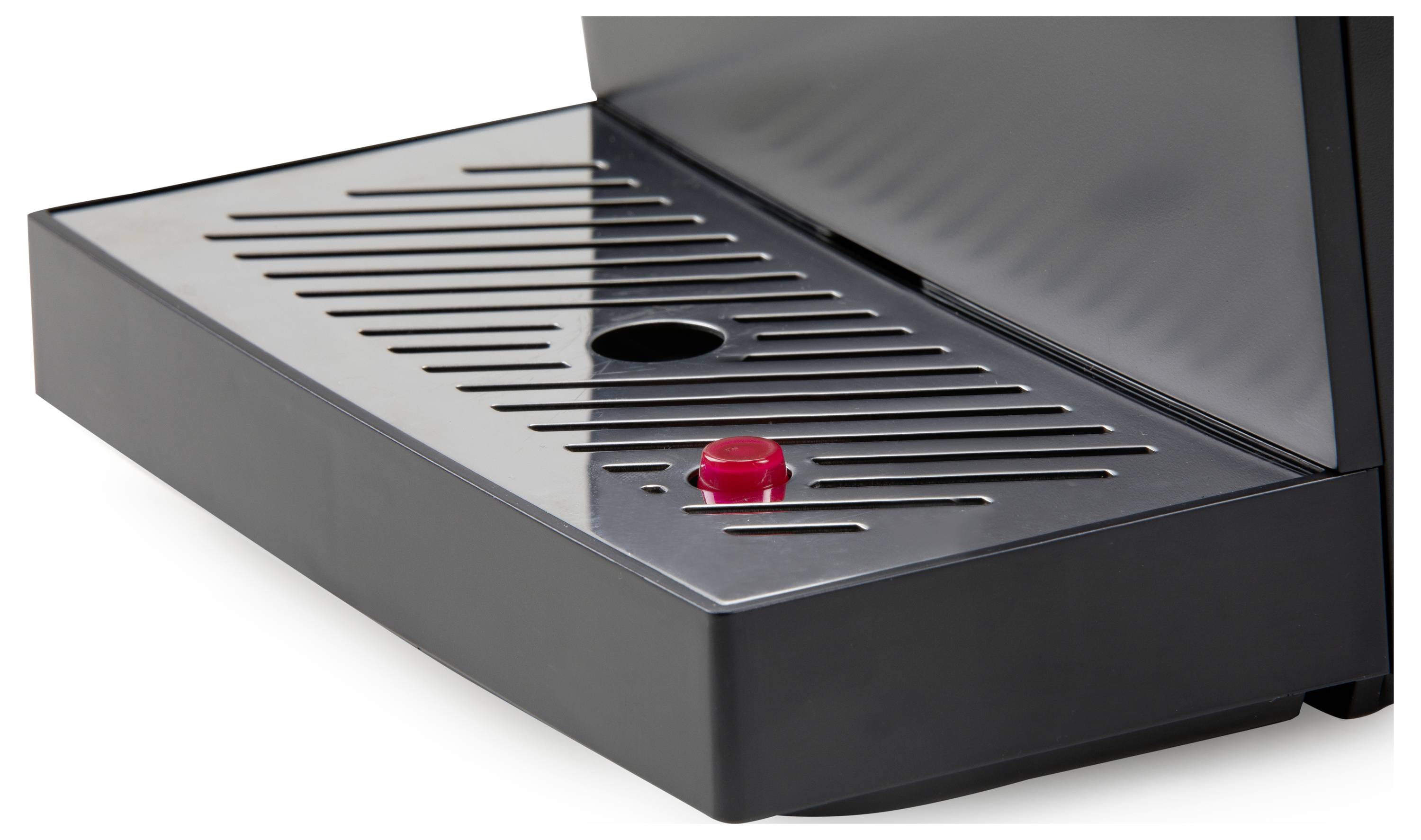 Een close-up van een zwarte lekbak met een rode knop in het midden, onderdeel van een koffiemachine.