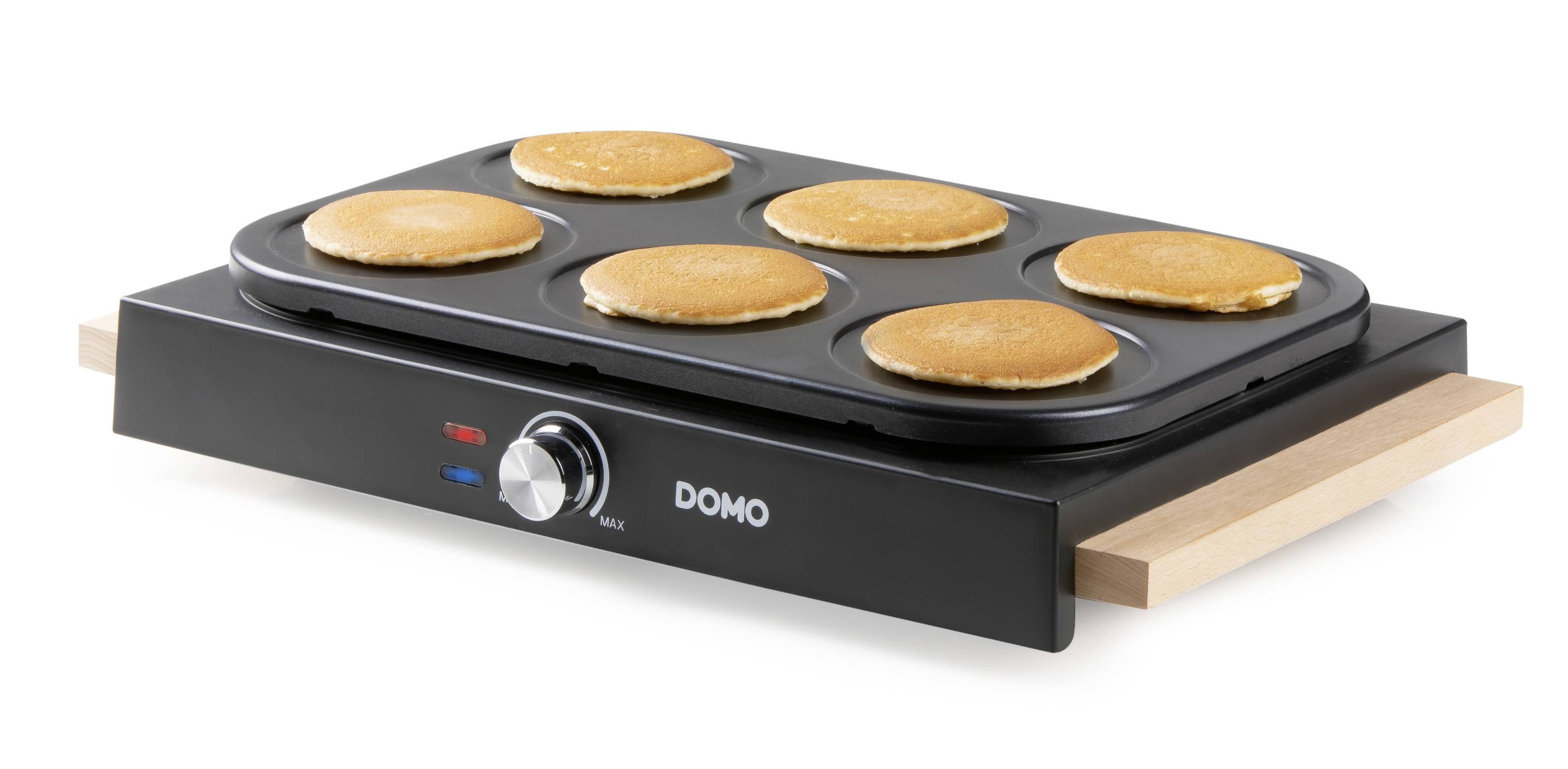 Een elektrisch apparaat voor pannenkoeken met zes ronde bakoppervlakken. Zes goudbruine pannenkoeken worden gelijkmatig gebakken.