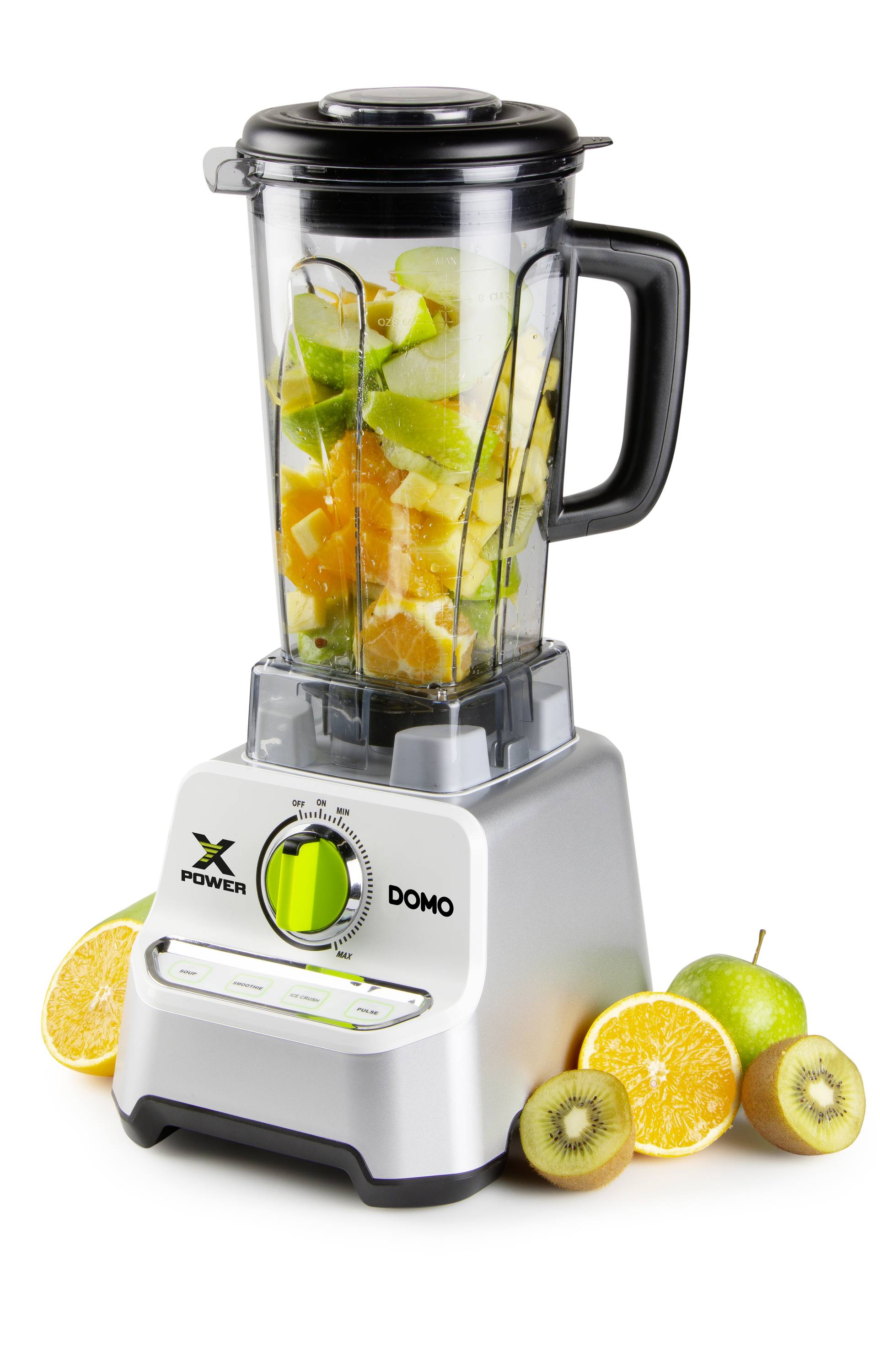Een staande blender met een open kan, gevuld met gesneden fruit. Ernaast liggen hele en gehalveerde vruchten.