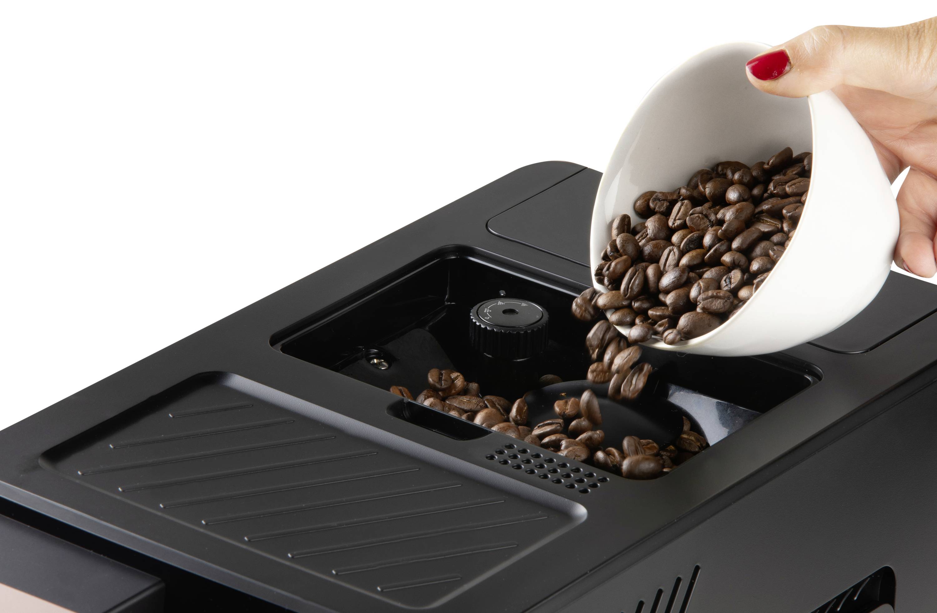 Een hand giet koffiebonen uit een witte schaal in de bonencontainer van een zwarte volautomatische koffiemachine.