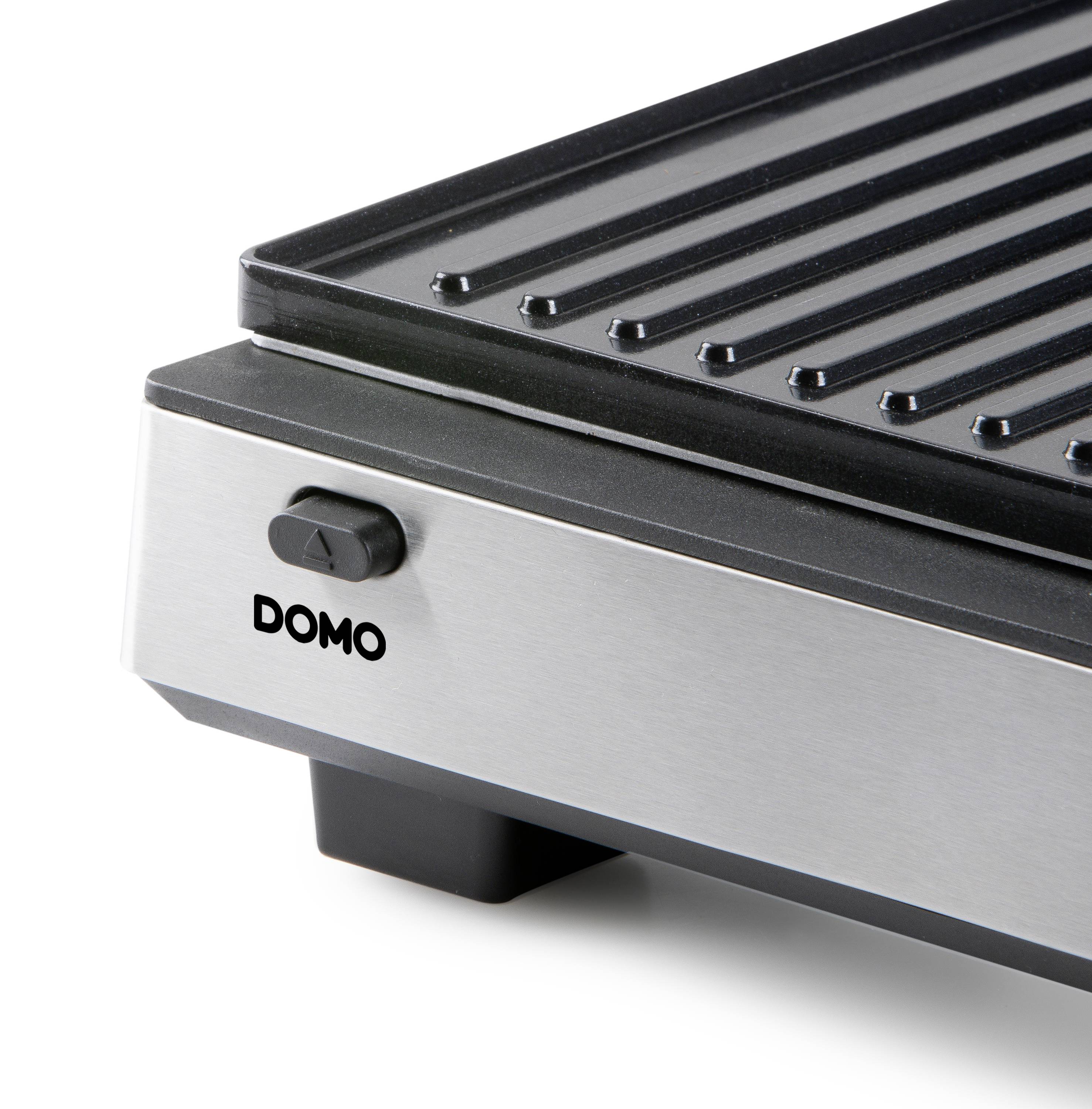 Een zilveren en zwarte grill met een geprofileerd oppervlak en een schakelaar aan de zijkant. Op de voorkant staat 'DOMO'.