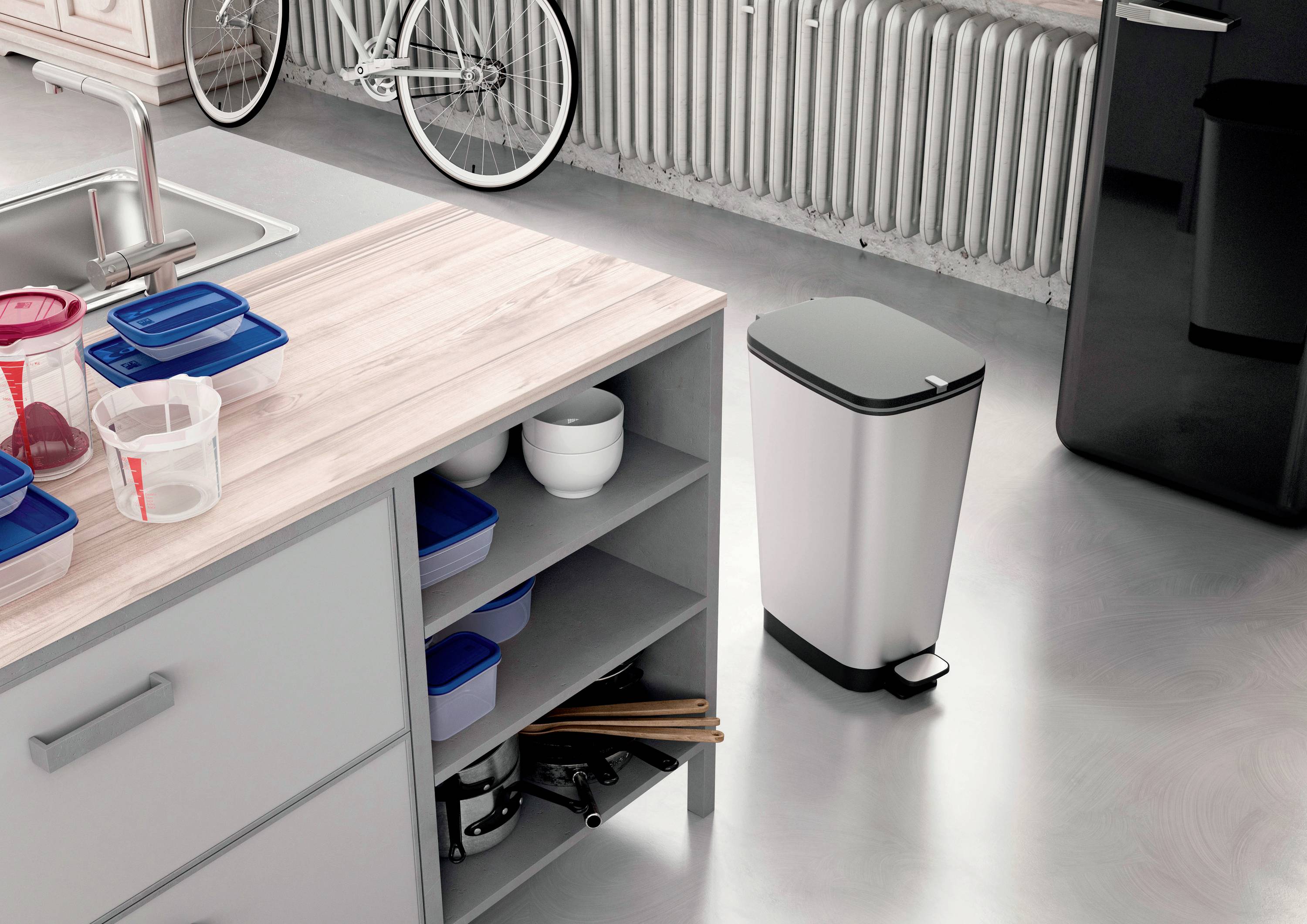 Een moderne keuken met een pedaalemmer naast een werkblad met open rekken en servies. Op de achtergrond staat een fiets.