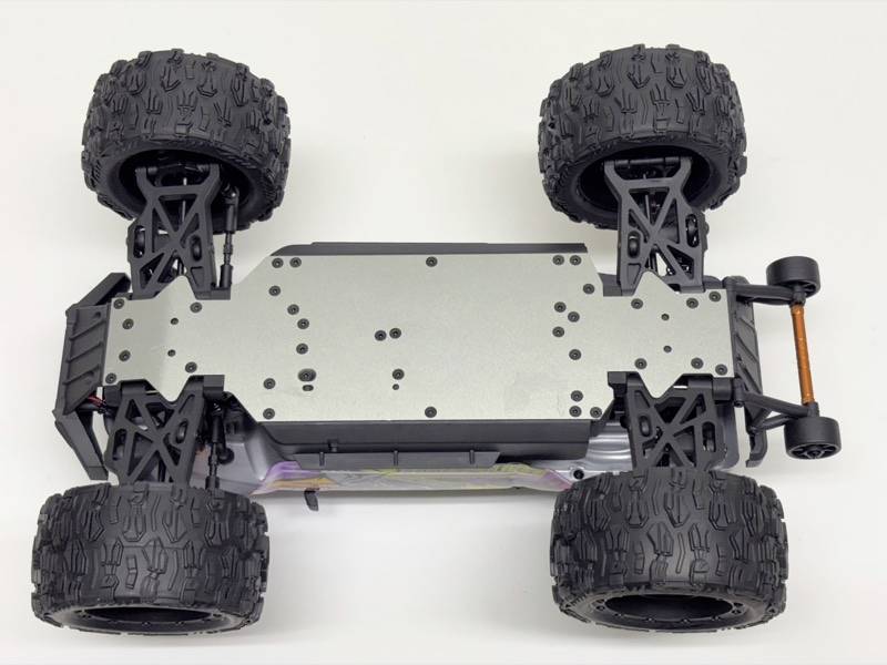 Een op afstand bestuurde auto van onderen, toont het chassis en de grote, robuuste banden voor terreinrijden.