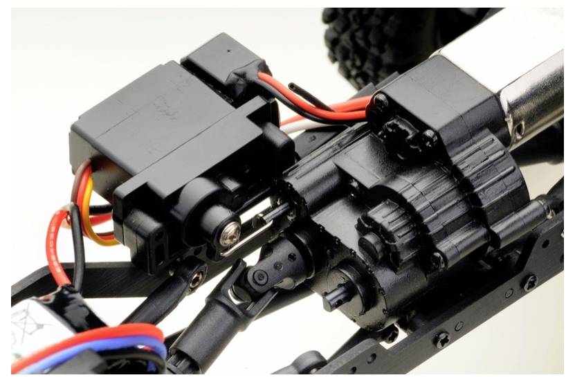 Close-up van een modelauto-versnellingsbak met bedrade elektrische componenten die met elkaar zijn verbonden.
