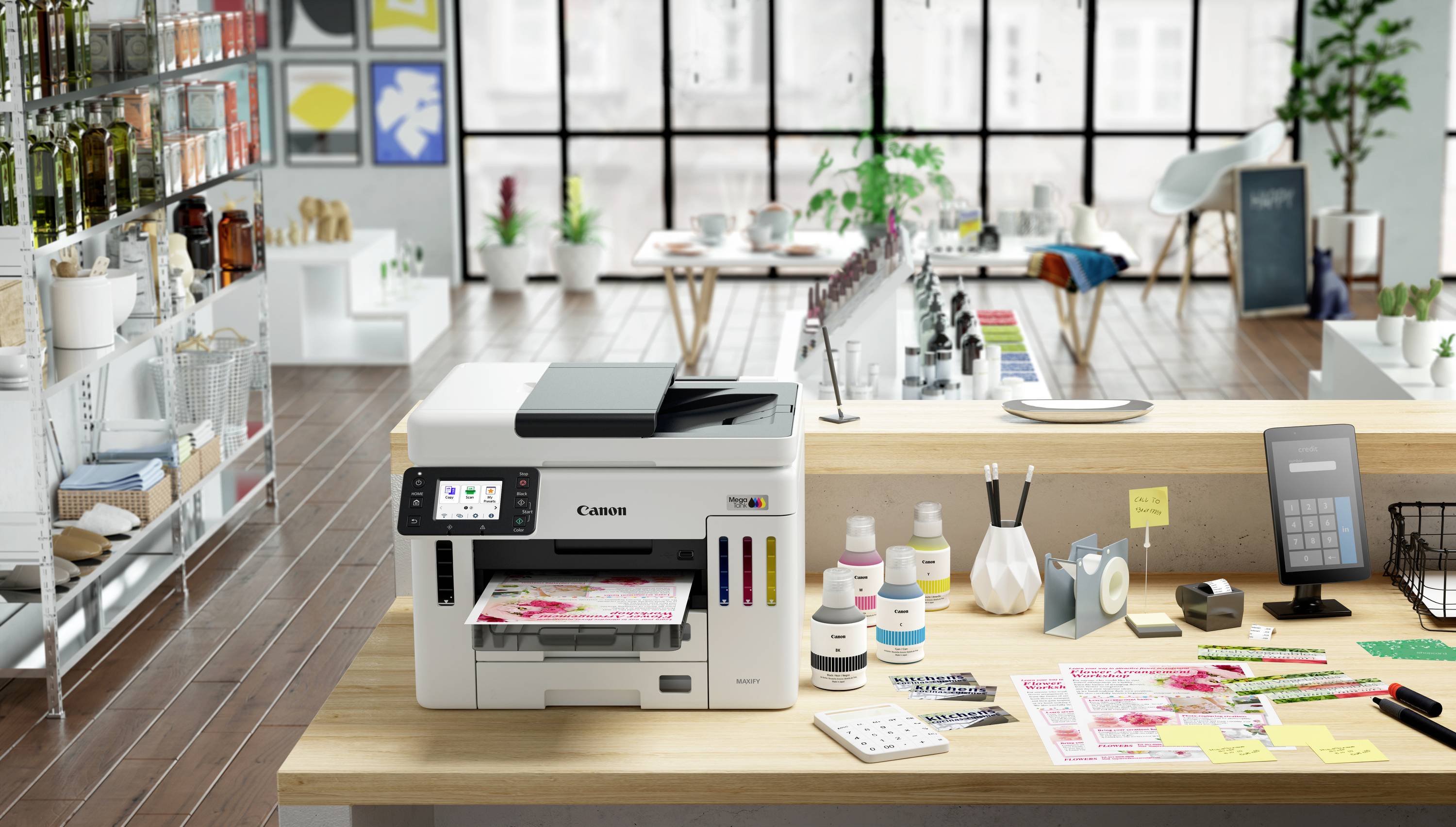 Een kantoor met een printer op een bureau, omringd door papieren, kantoorbenodigdheden en moderne meubels in een lichte ruimte.