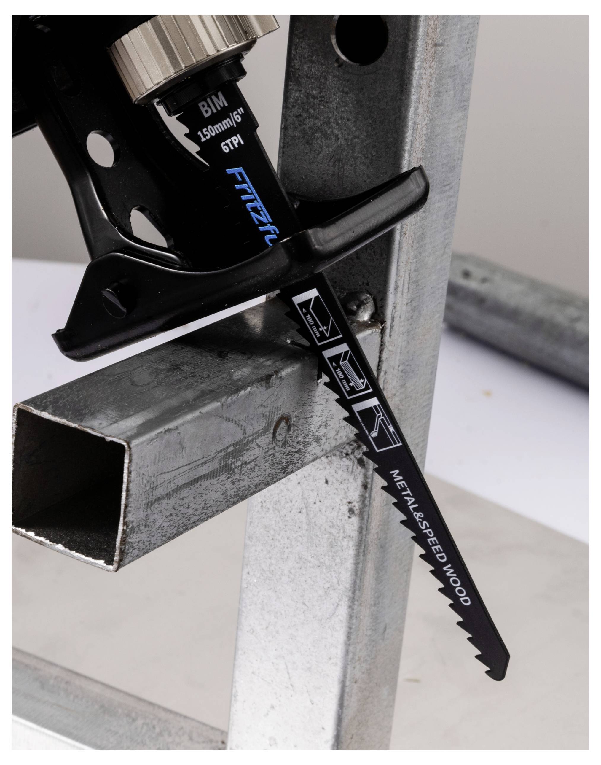 Een zaagblad gelabeld als 'Metal & Speed Wood' die aan een reciprozaag is bevestigd, zaagt door een metalen buis.