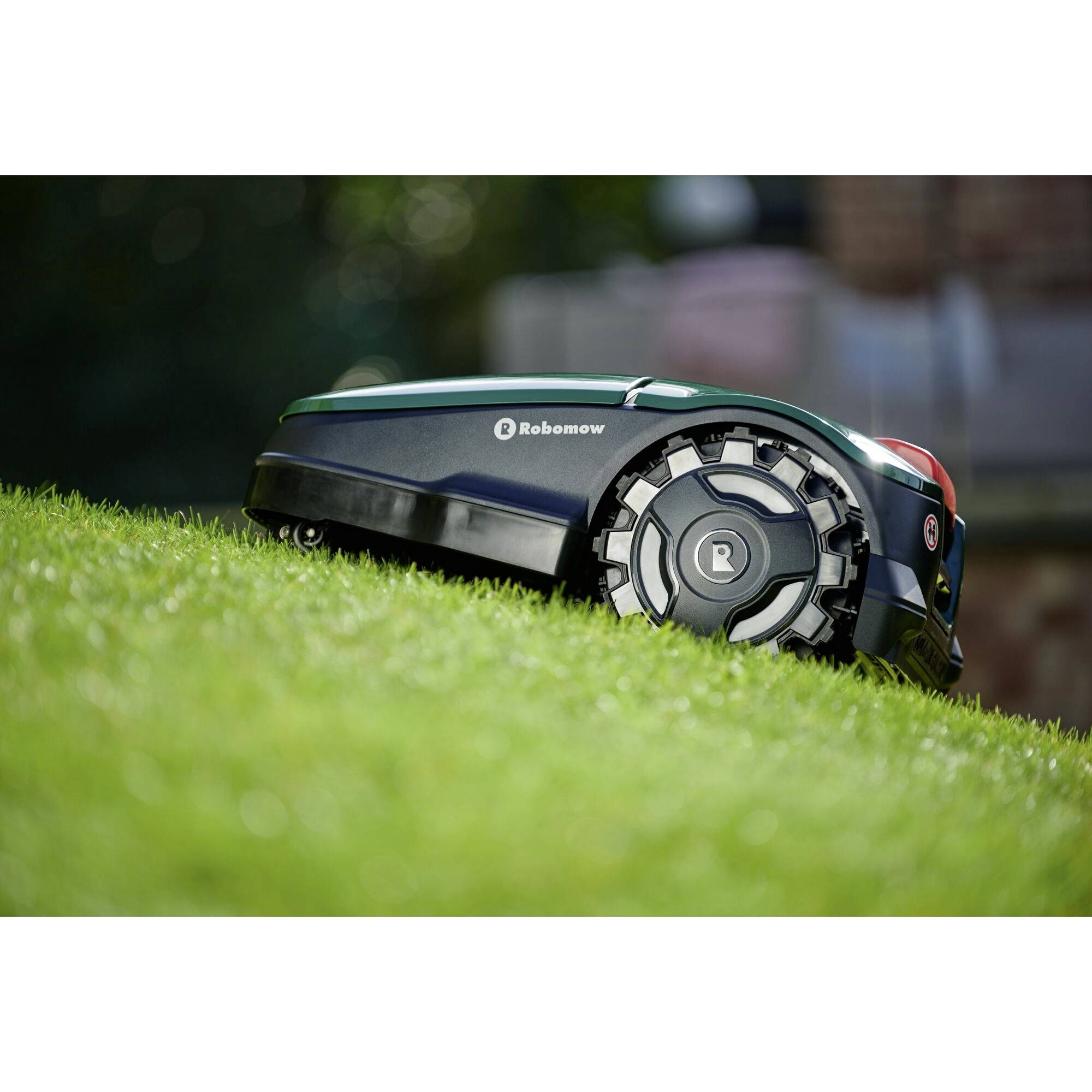 Een maairobot rijdt autonoom over een groene, licht hellende grasvlakte.