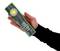 Een hand houdt een zwarte zaklamp met groene rand en de aanduiding '1200 Lumen' op de voorkant.
