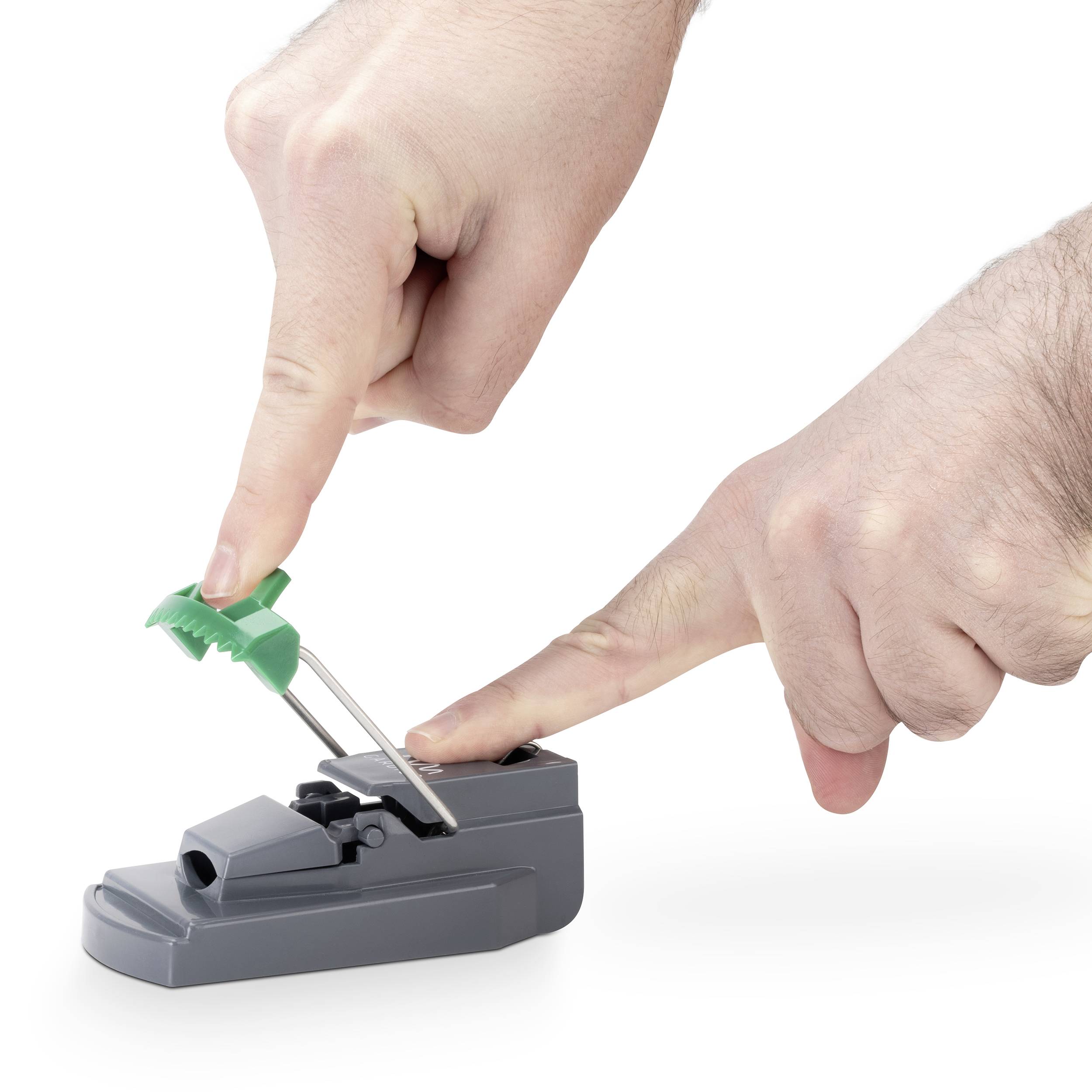 Een hand drukt een groene borstel in een tandenzijdehouder op een grijze steun.