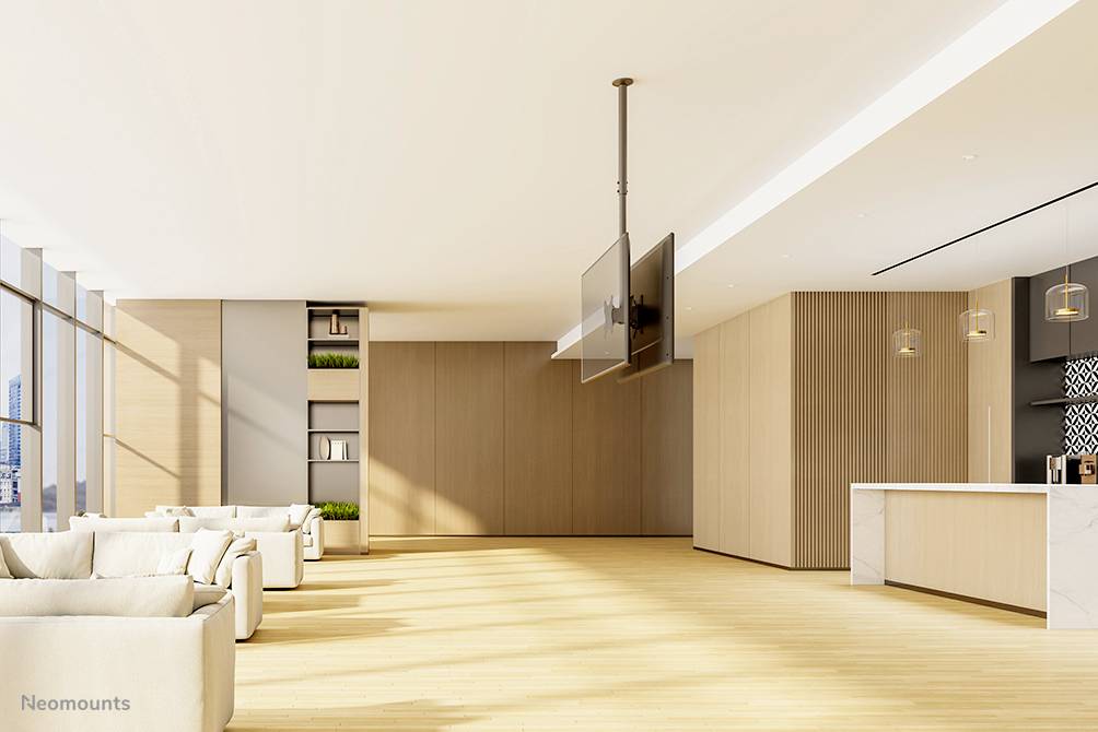 Lichte, moderne lounge met banken en grote ramen. Een open keuken met een balie bevindt zich op de achtergrond.